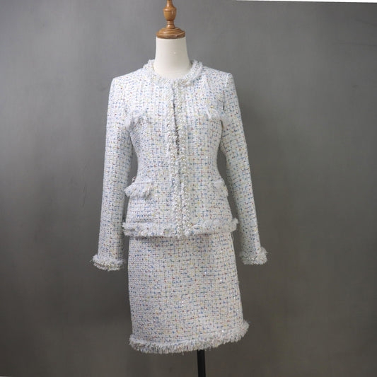 Step into sophistication with this custom-made white tweed skirt suit, designed to make you stand out at any special occasion. Featuring delicate confetti dot detailing and chic tassel fringe, this luxurious ensemble is tailored to perfection for a polished and elegant look.