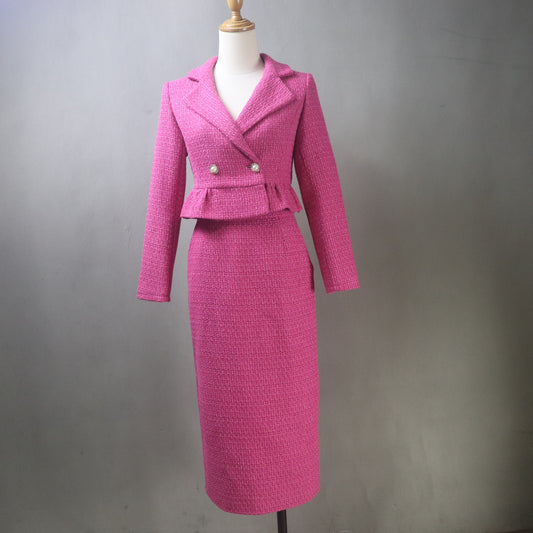 Hot pink tweed two-piece midi skirt suit on mannequin, featuring a cropped peplum jacket with double pearl buttons and a fitted pencil skirt, displayed against a neutral gray background.