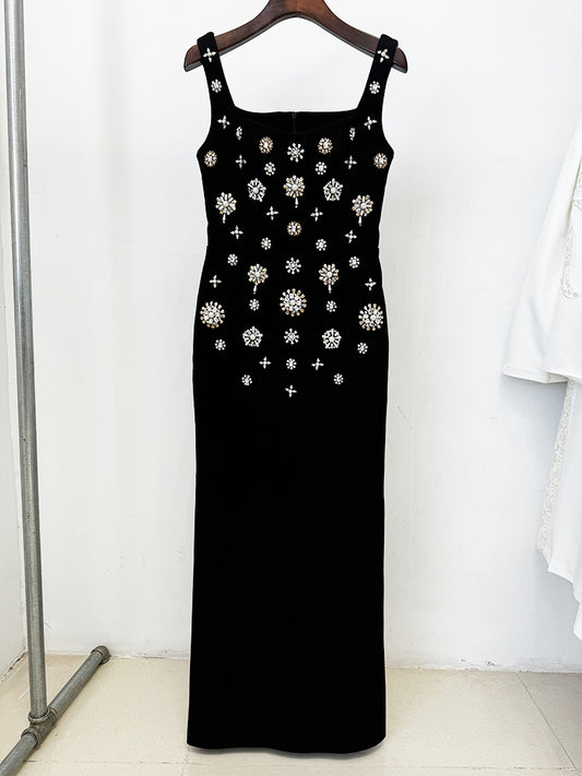 Black dress with white floral embellishments on a hanger against a white background
