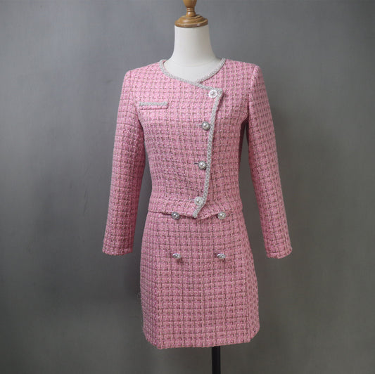 Front view of a bespoke pink tweed skirt suit on a mannequin, featuring an asymmetrical button jacket and short skirt.