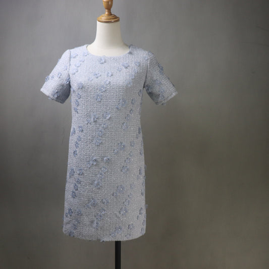 Short-sleeve dress with floral pattern on a mannequin against a gray background