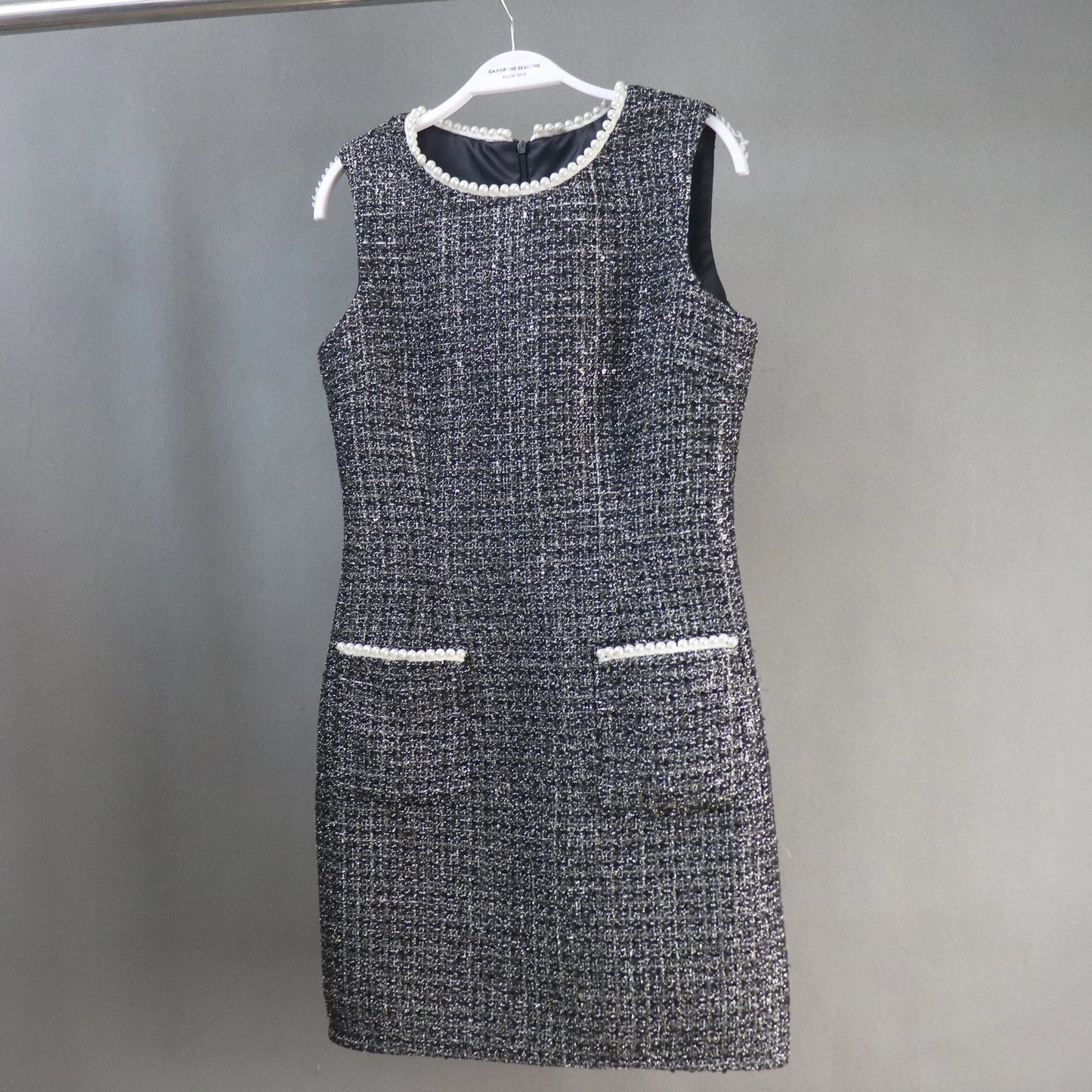 This dazzling FASHION Sequinned tweed little dress will stun everyone with its glamorous notes! This slim-fit black dress is made of a mid-weight tweed with dazzling lame accents, small sequins with white chiffon trims, and is lined with black satin. This dress also has a high neckline with trims, a sleeveless design,