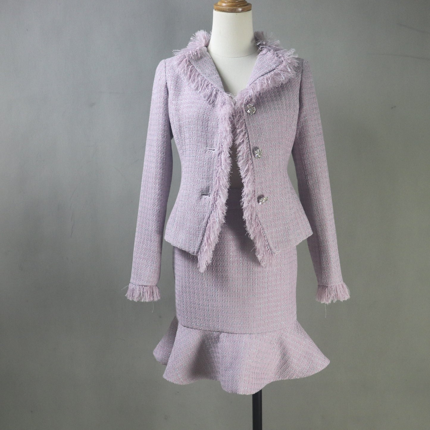 Purple textured suit with frayed edges on a mannequin against a gray background