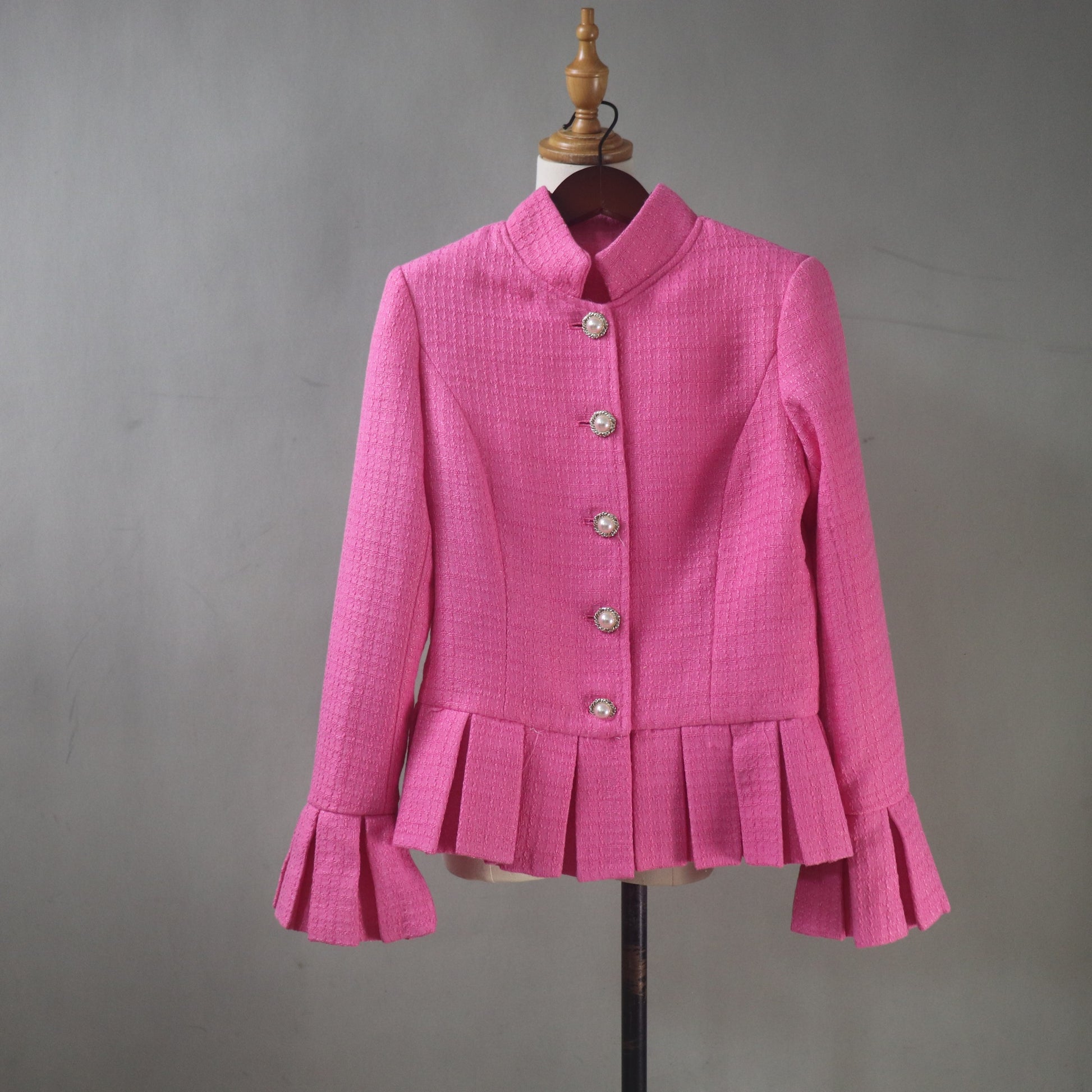 Handmade pink tweed two-piece suit featuring pearl buttons, tailored fit, and elegant feminine details.
