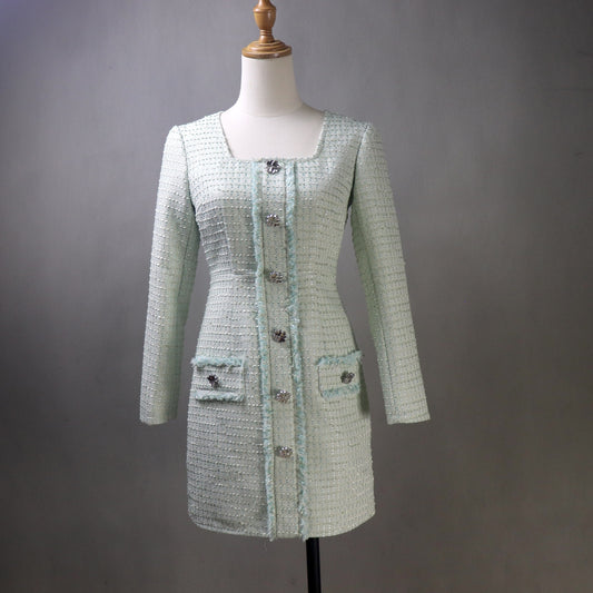 Light green tweed dress on a mannequin against a gray background