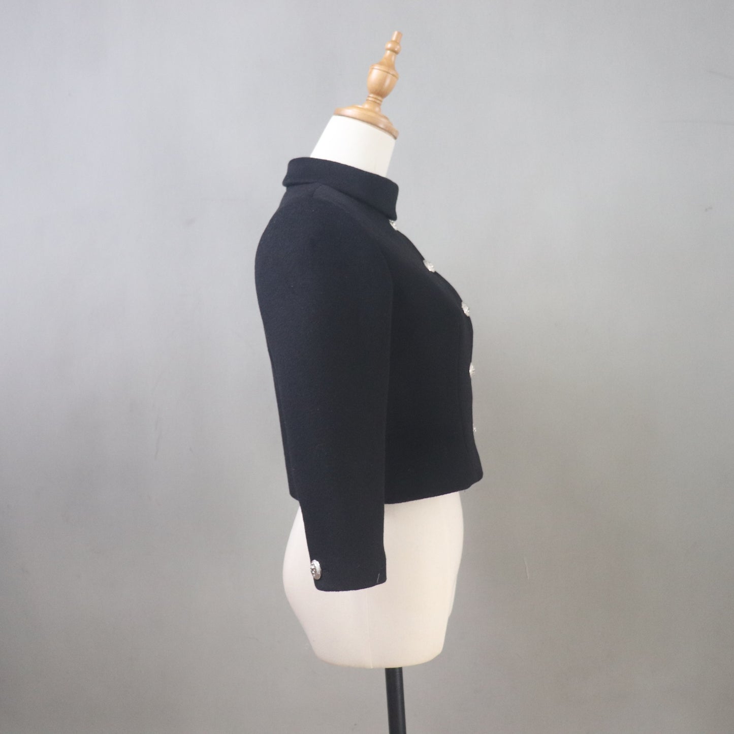 Black jacket on a mannequin against a gray background