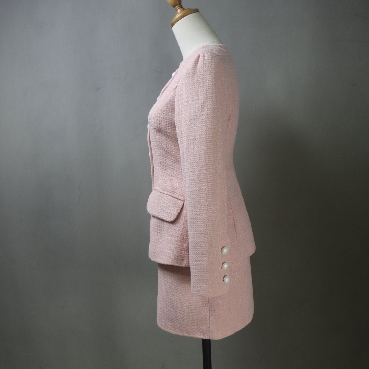 Pink blazer on a mannequin against a gray background