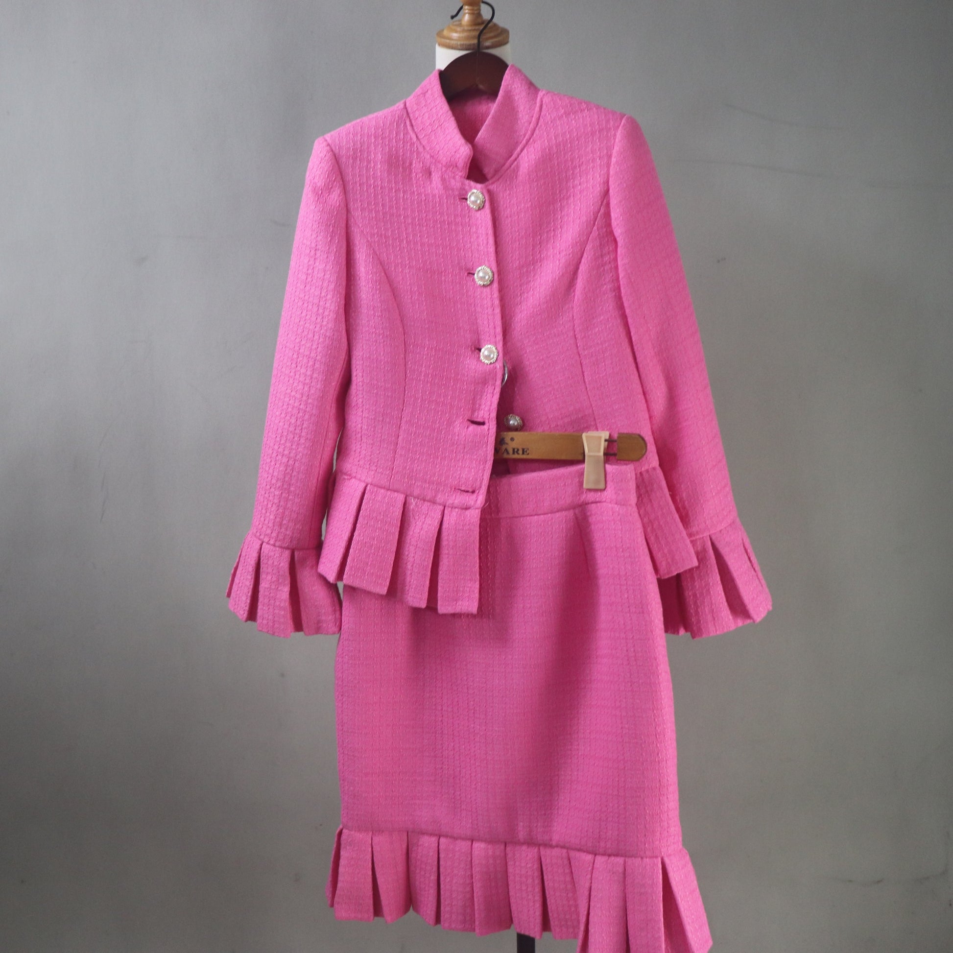 Mother of the bride pink tweed suit with peplum waist, long sleeves, and sophisticated classic design.