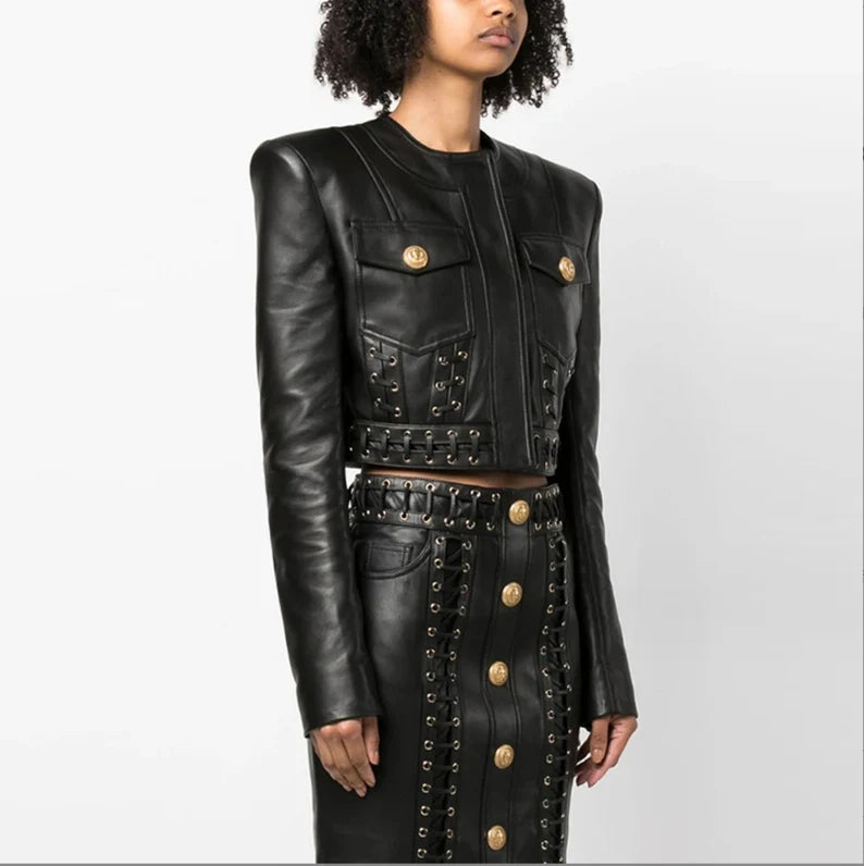 Step into the spotlight with our Women's Fitted Faux Leather Golden Buttons Straps Short Crop Jacket + Mini Skirt Suit in sleek black, perfect for pop concerts and evening events. This edgy ensemble combines the allure of faux leather with golden buttons and stylish straps, creating a captivating look that's both bold and glamorous. The fitted crop jacket exudes a biker-chic vibe, making it an ideal choice for those who crave a touch of rebellion in their fashion. 