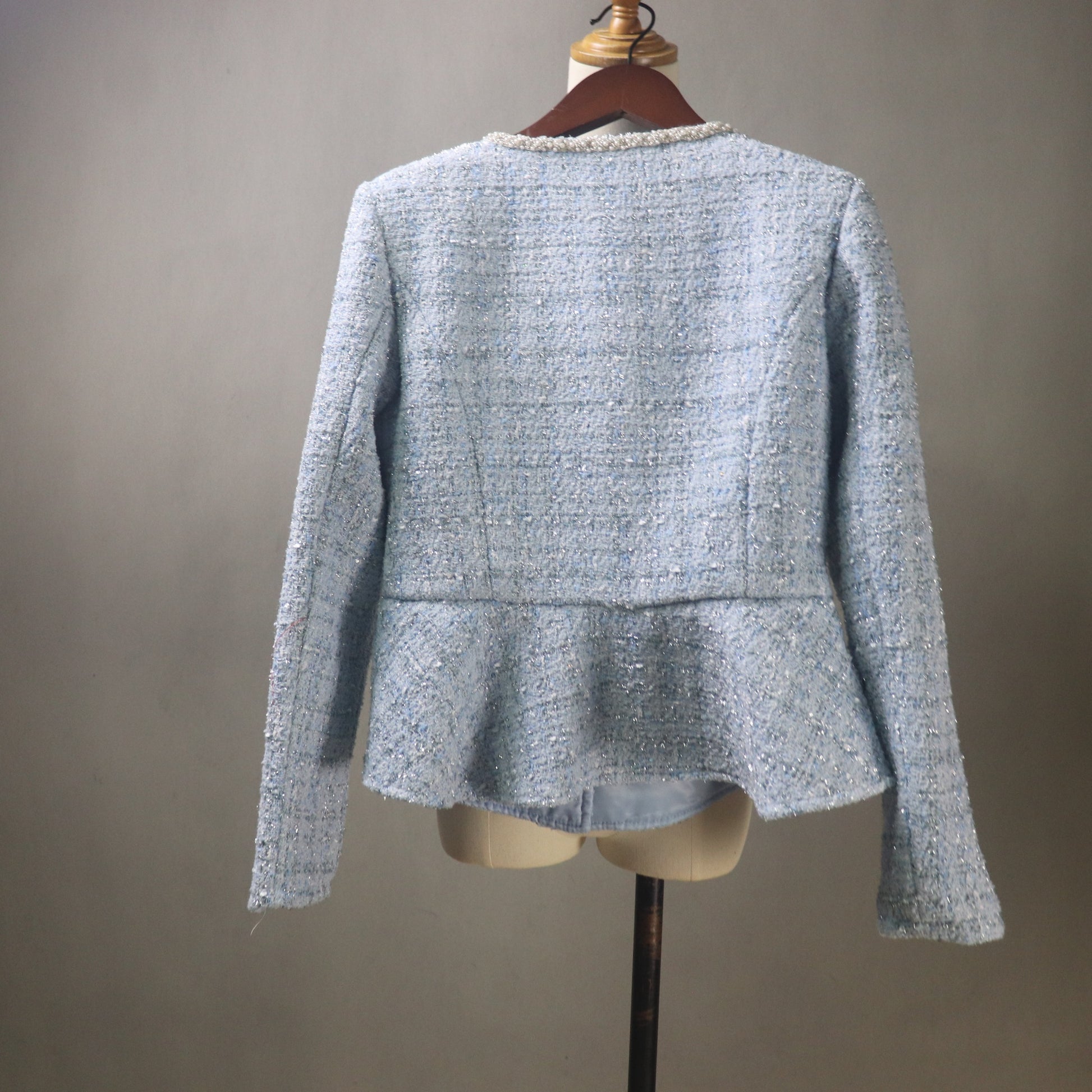 Light blue textured jacket on a mannequin against a gray background