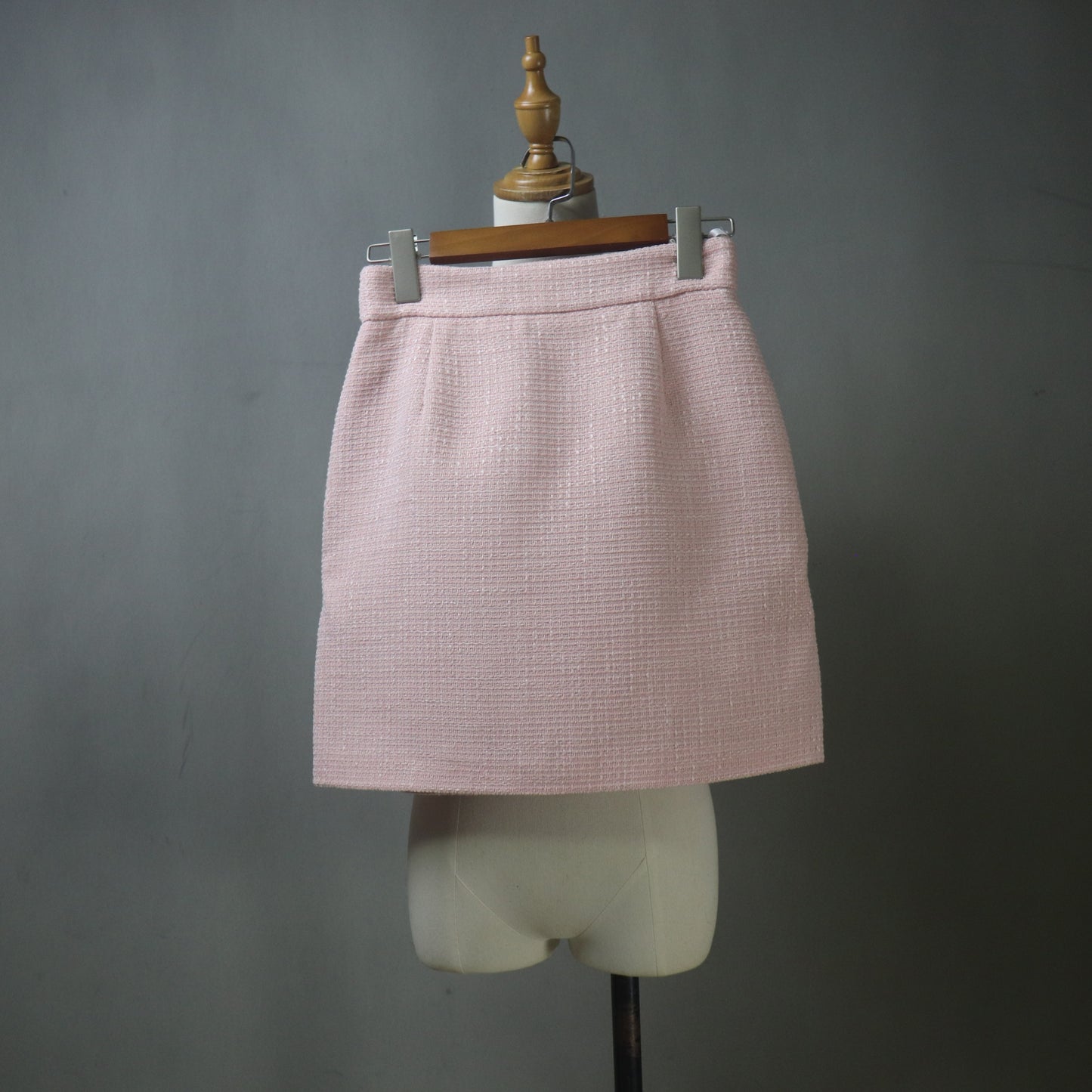 Pink skirt on a mannequin against a gray background