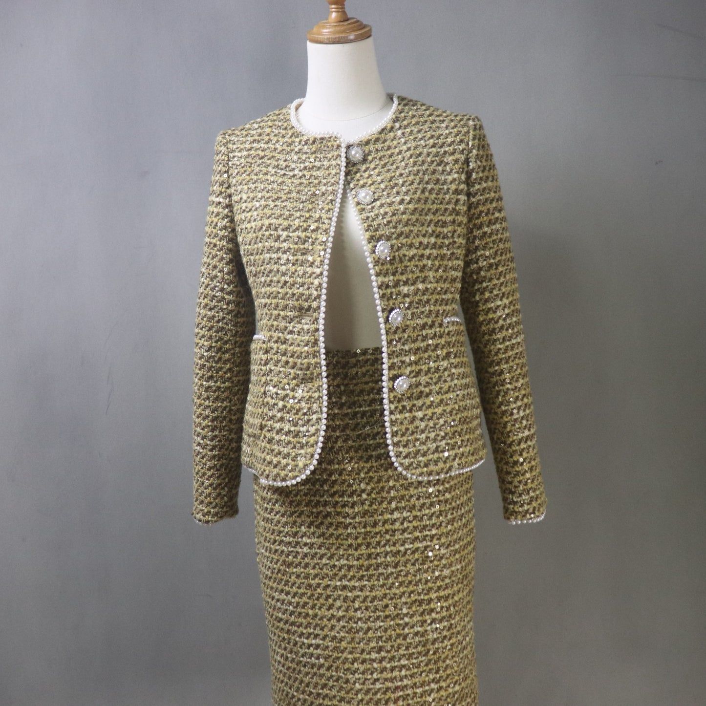 Two-piece tweed suit on a mannequin against a gray background