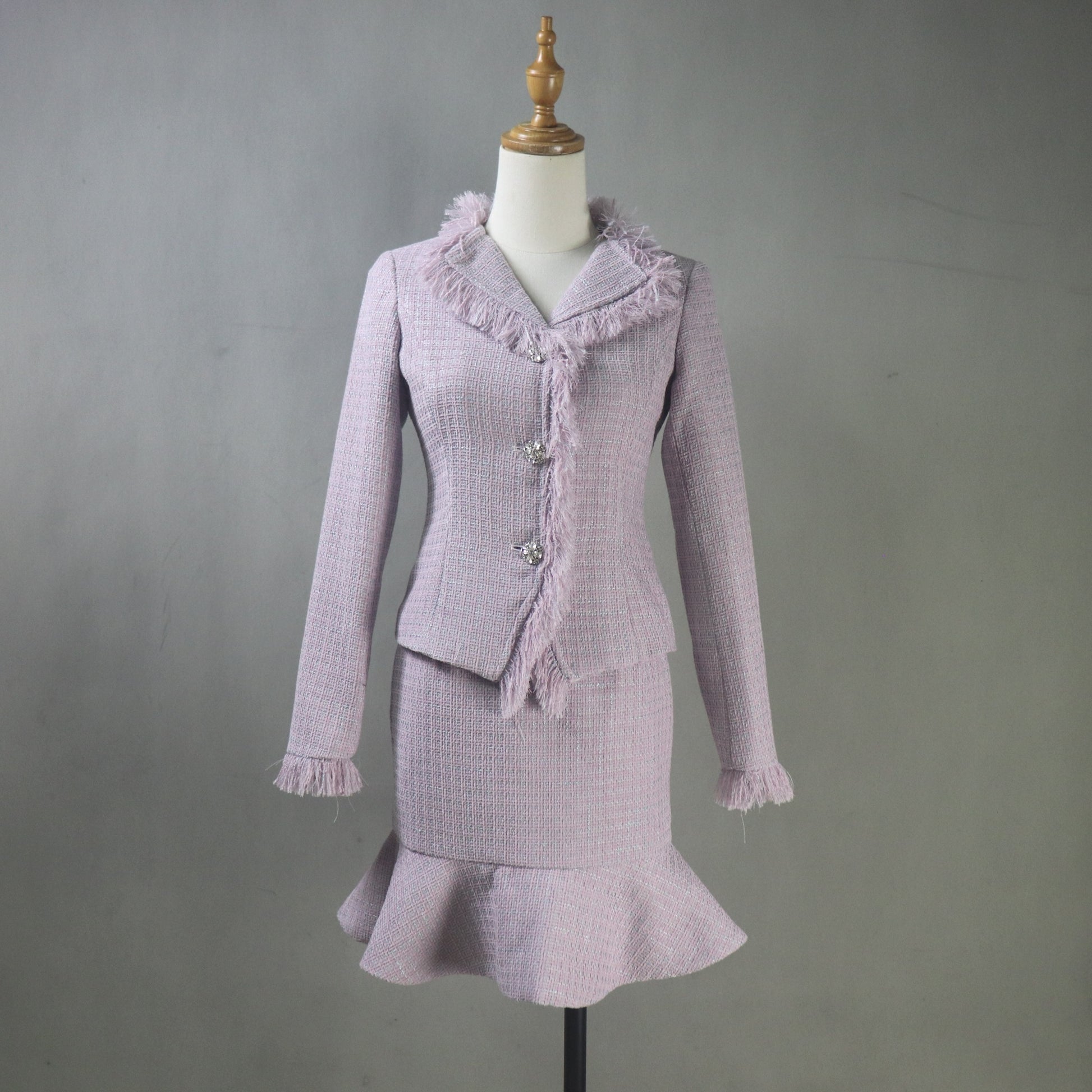 Purple vintage-style suit on a mannequin against a gray background