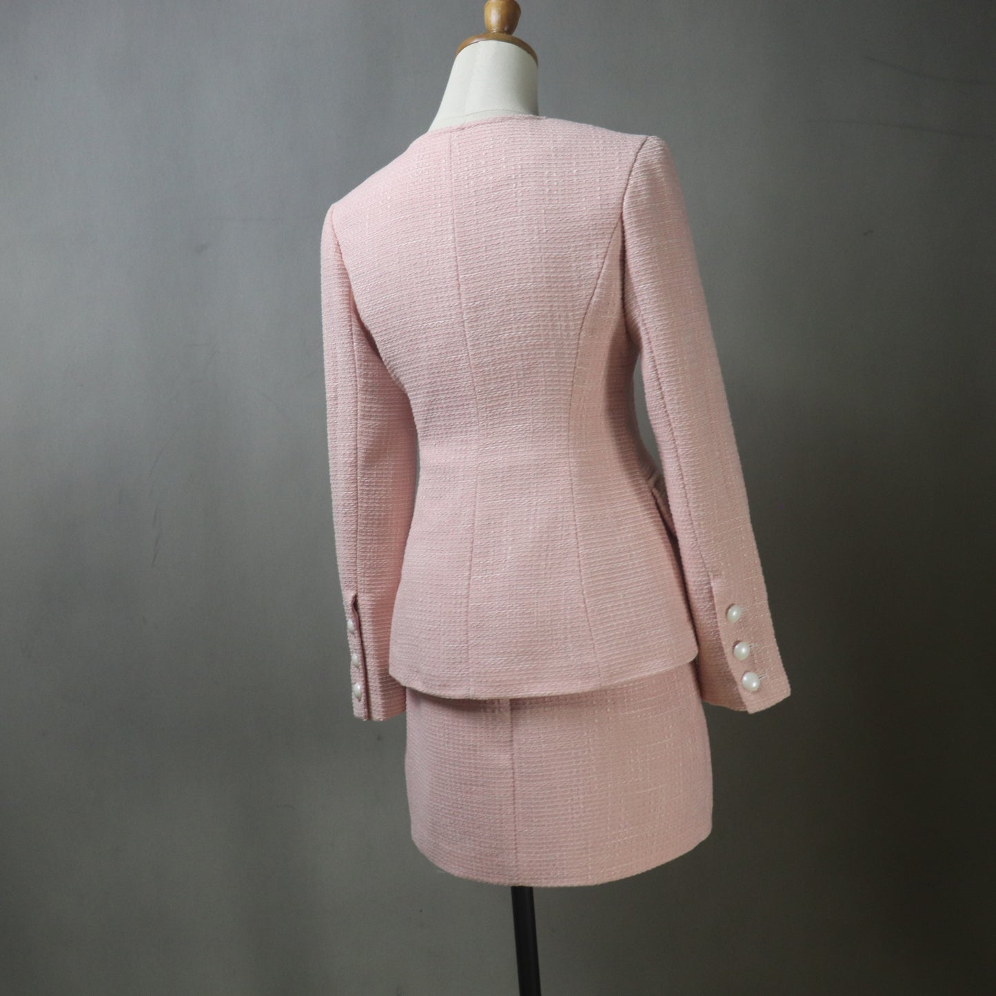 Pink checkered suit on a mannequin against a gray background