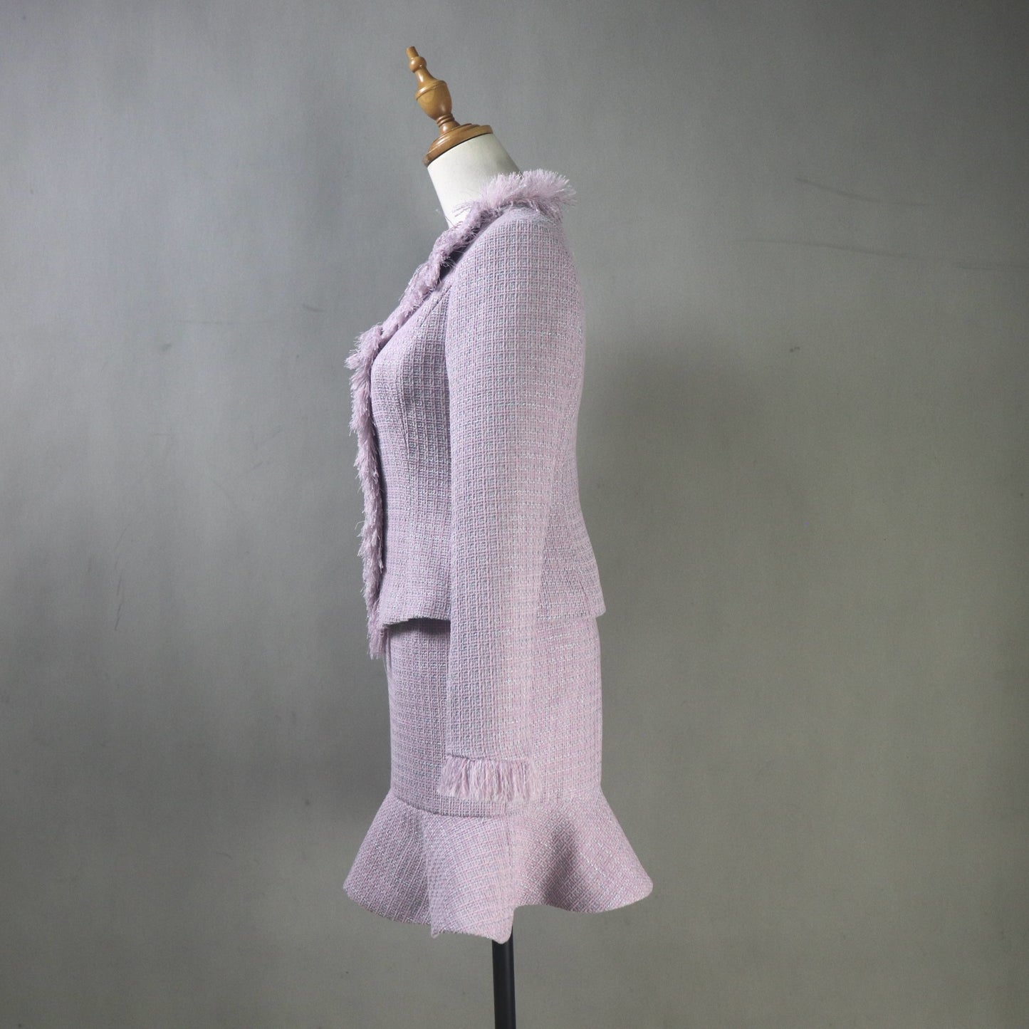 Light purple textured dress on a mannequin against a gray background