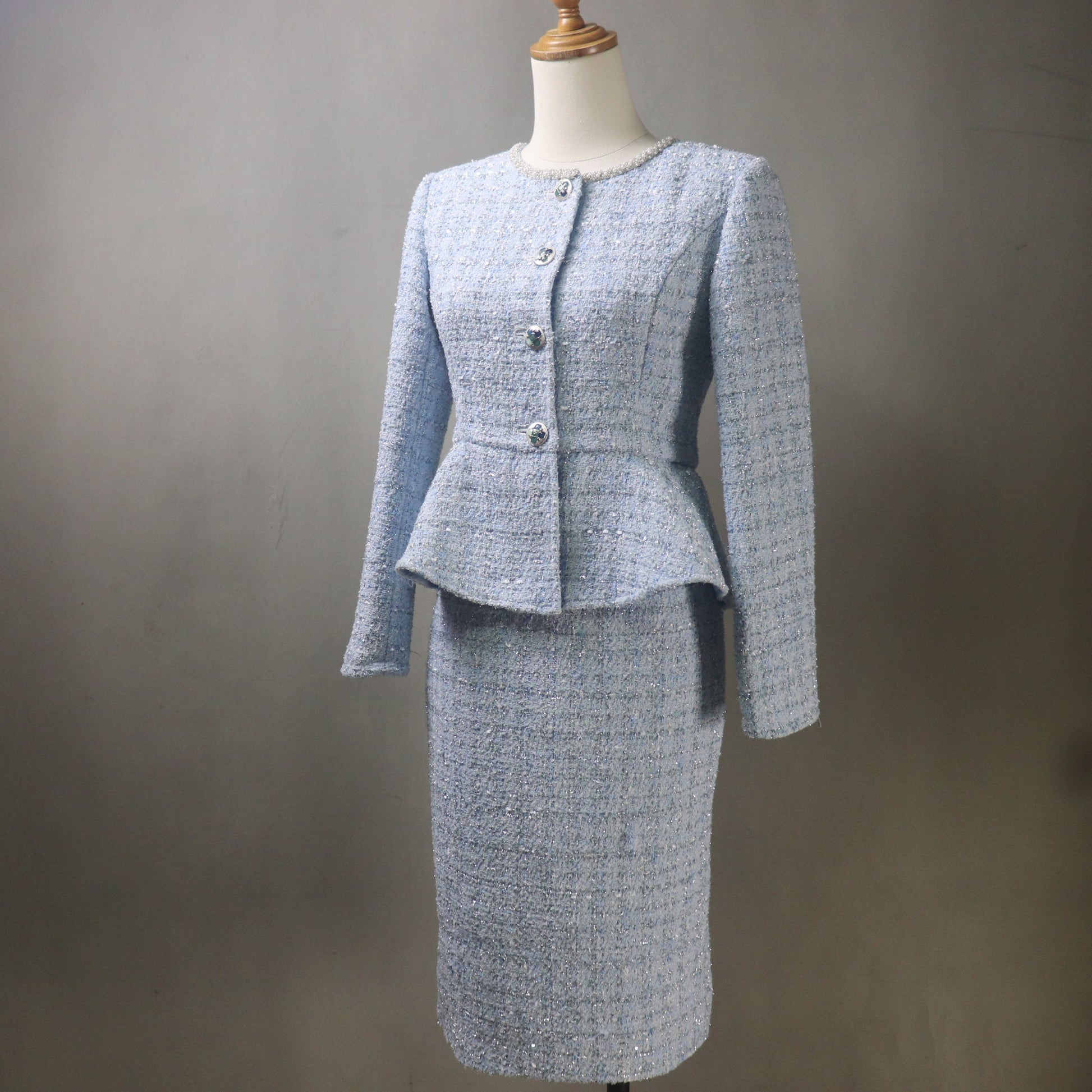 Light blue tweed suit on a mannequin against a gray background