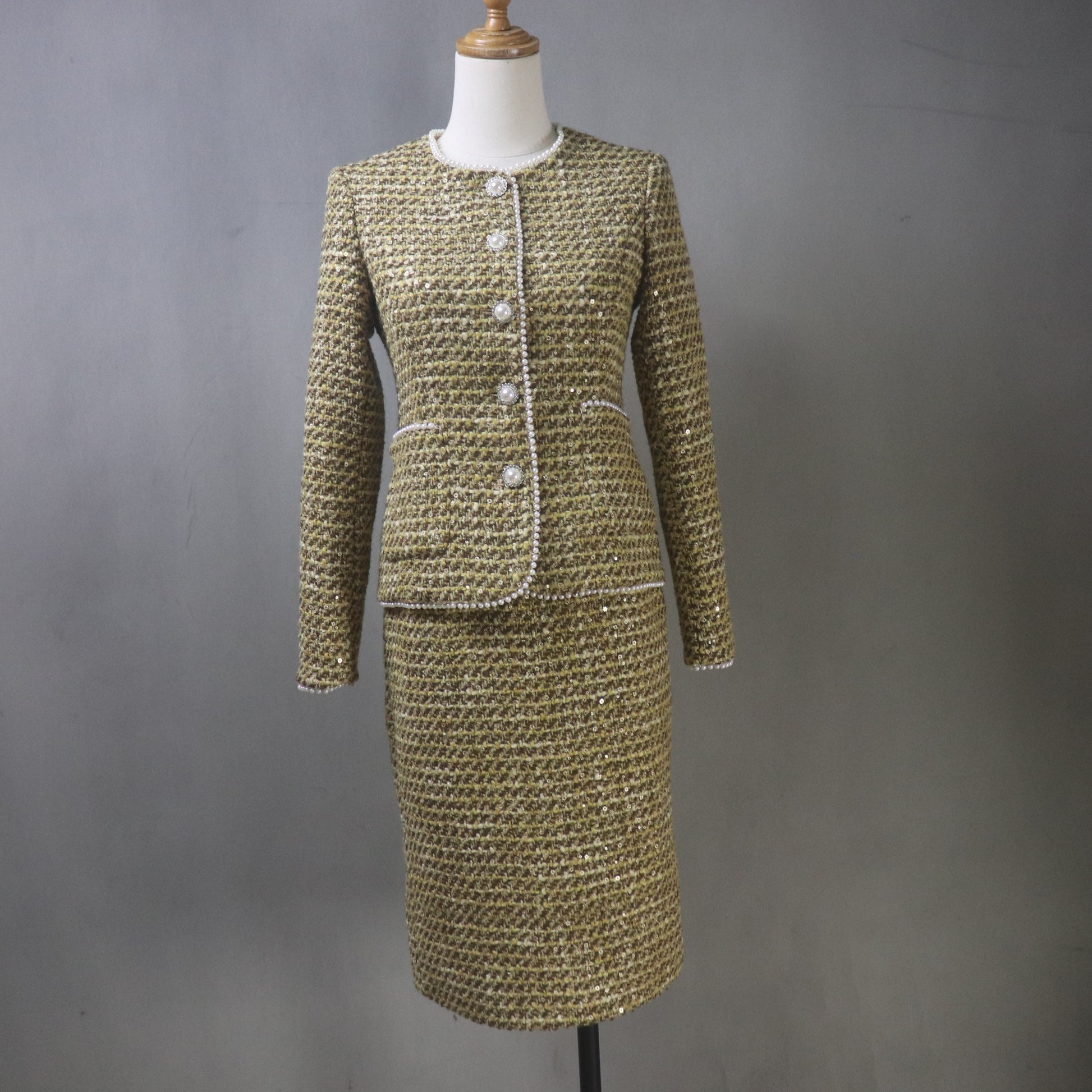 old yellow brown tweed skirt suit with sequins, pearl trim, and pearl buttons, displayed on mannequin; custom-made women’s outfit with fitted jacket and matching knee-length skirt.