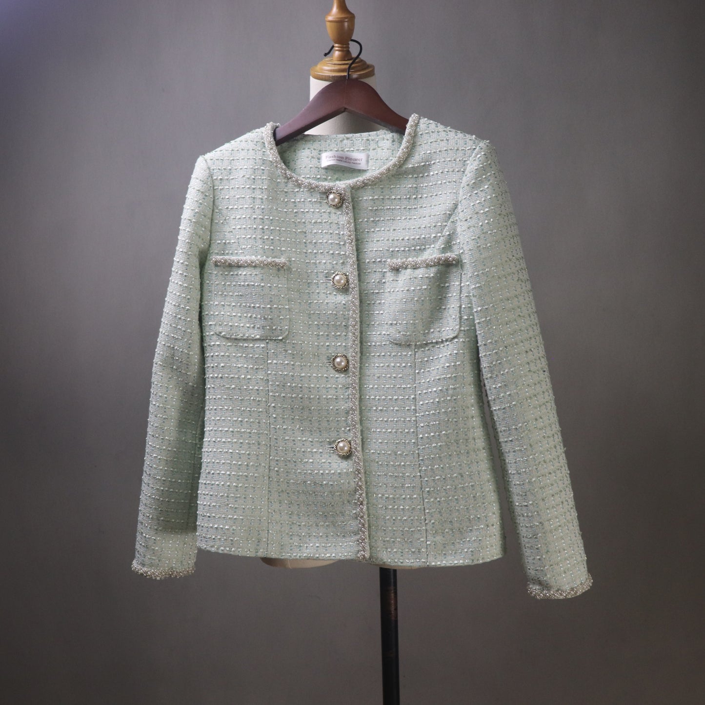 Light green textured jacket on a mannequin against a gray background
