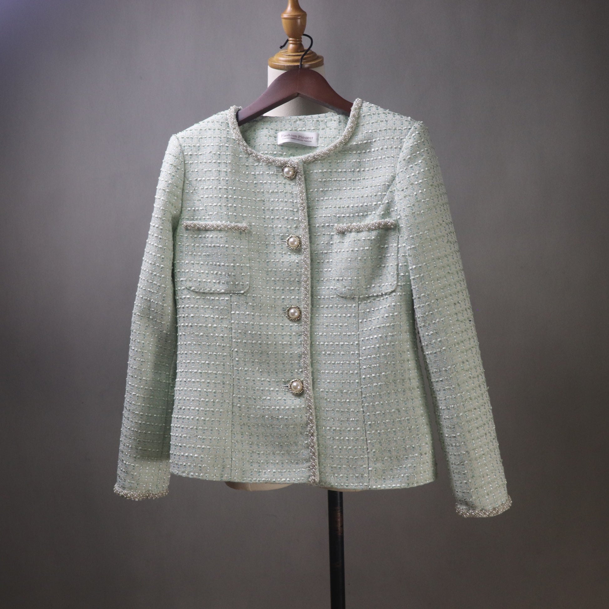 Light green textured jacket on a mannequin against a gray background