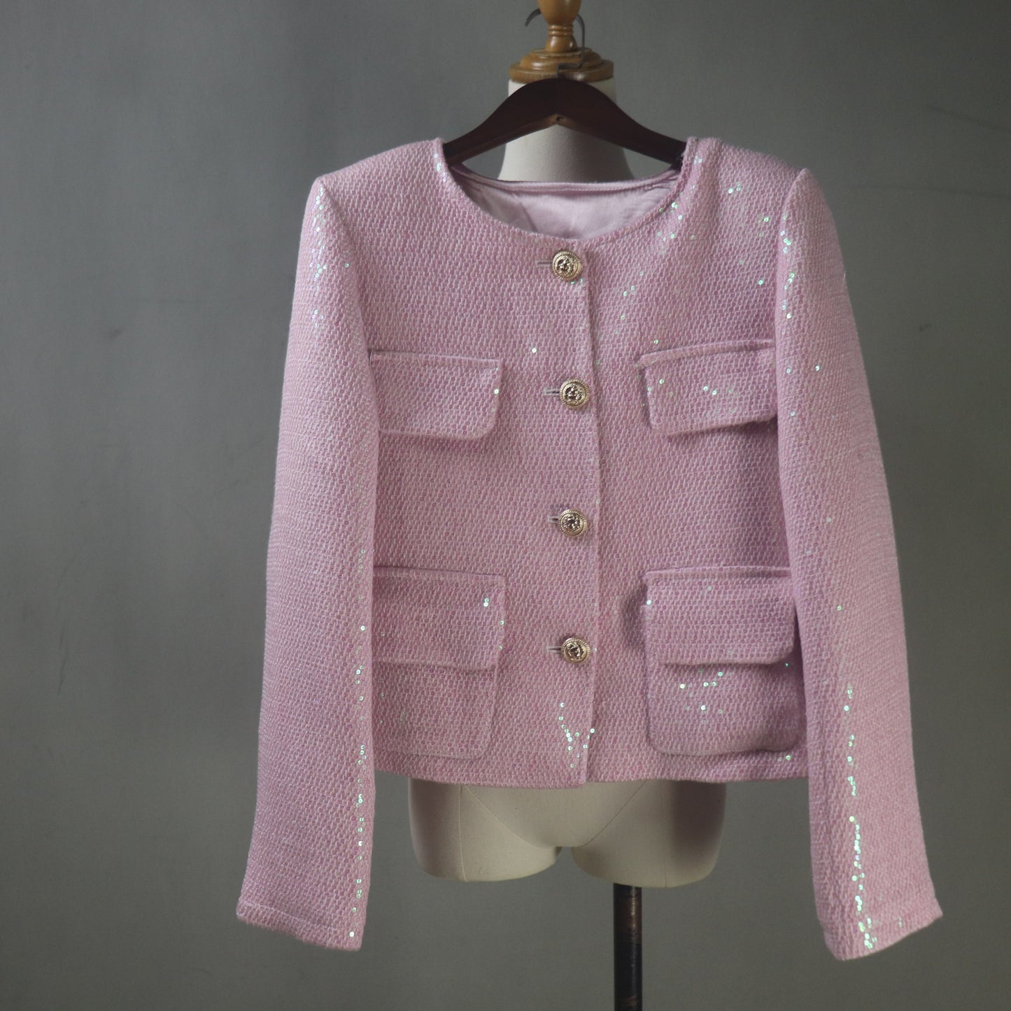 Pink sequined jacket on a mannequin against a gray background