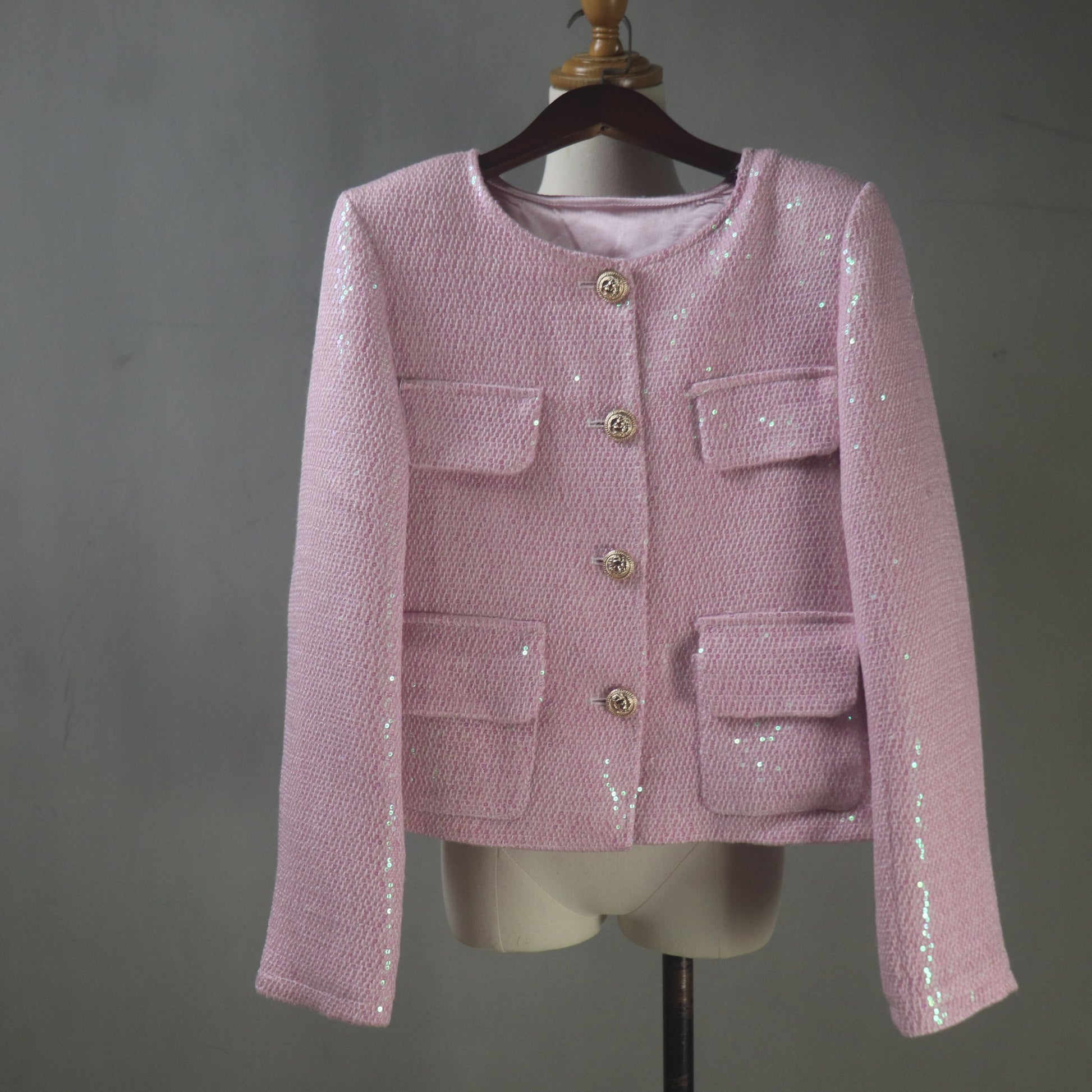 Pink sequined jacket on a mannequin against a gray background