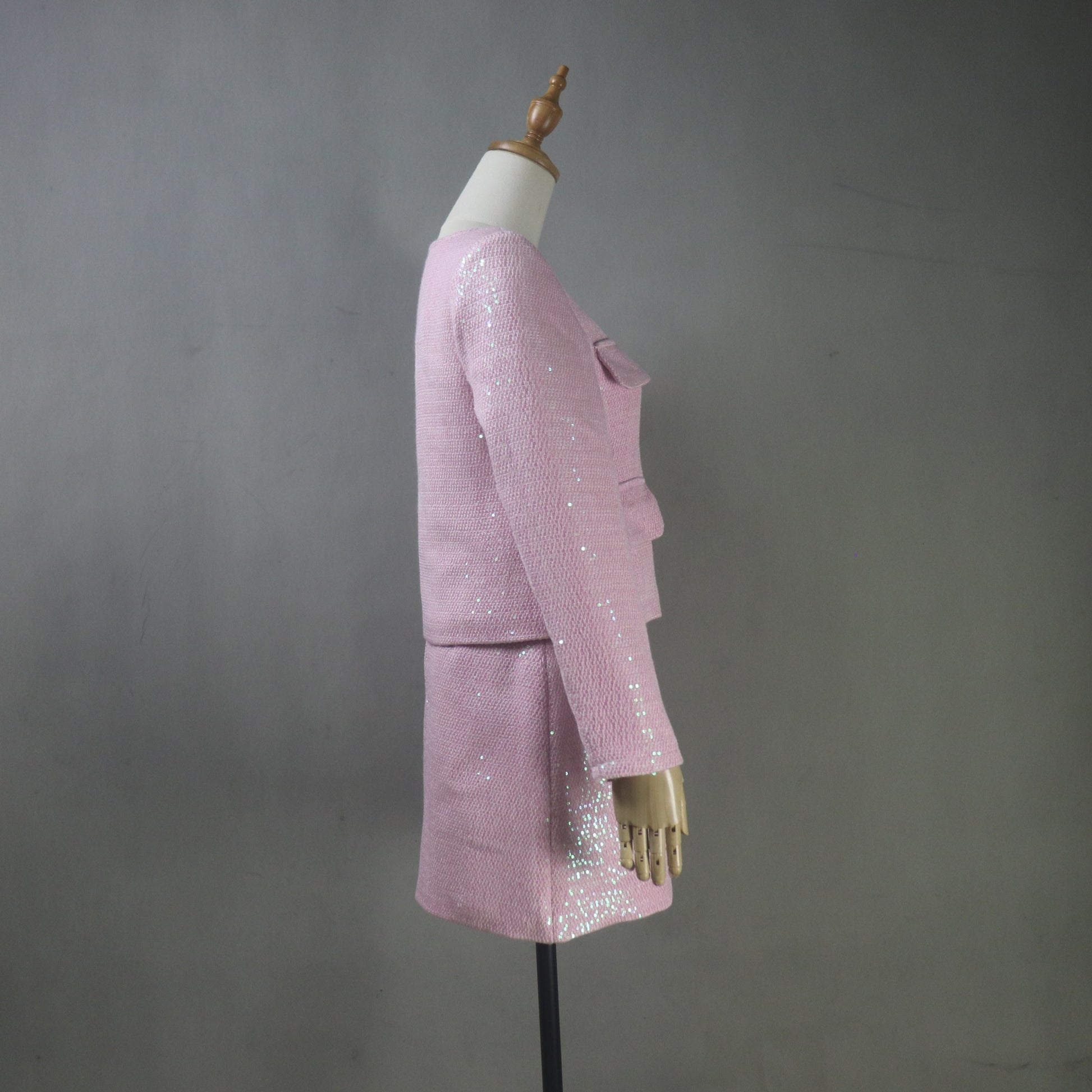 Pink sequin outfit on a mannequin against a gray background
