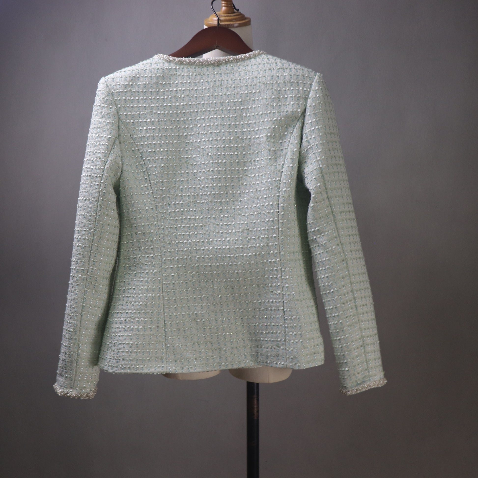 Light green textured blazer on a mannequin against a gray background
