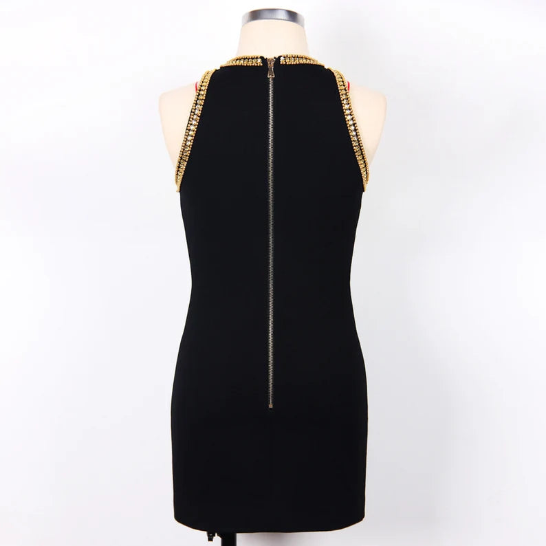 The black color of the dress provides a classic and versatile base, allowing the golden metal decorations to stand out even more. Black is known for its ability to create a flattering and slimming effect, making it a popular choice for various occasions.