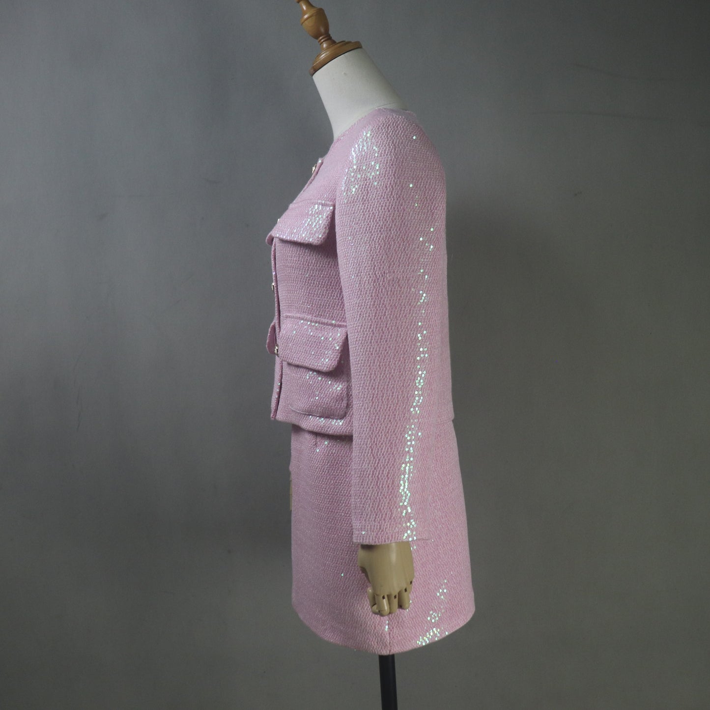 Pink sequin jacket on a mannequin against a gray background