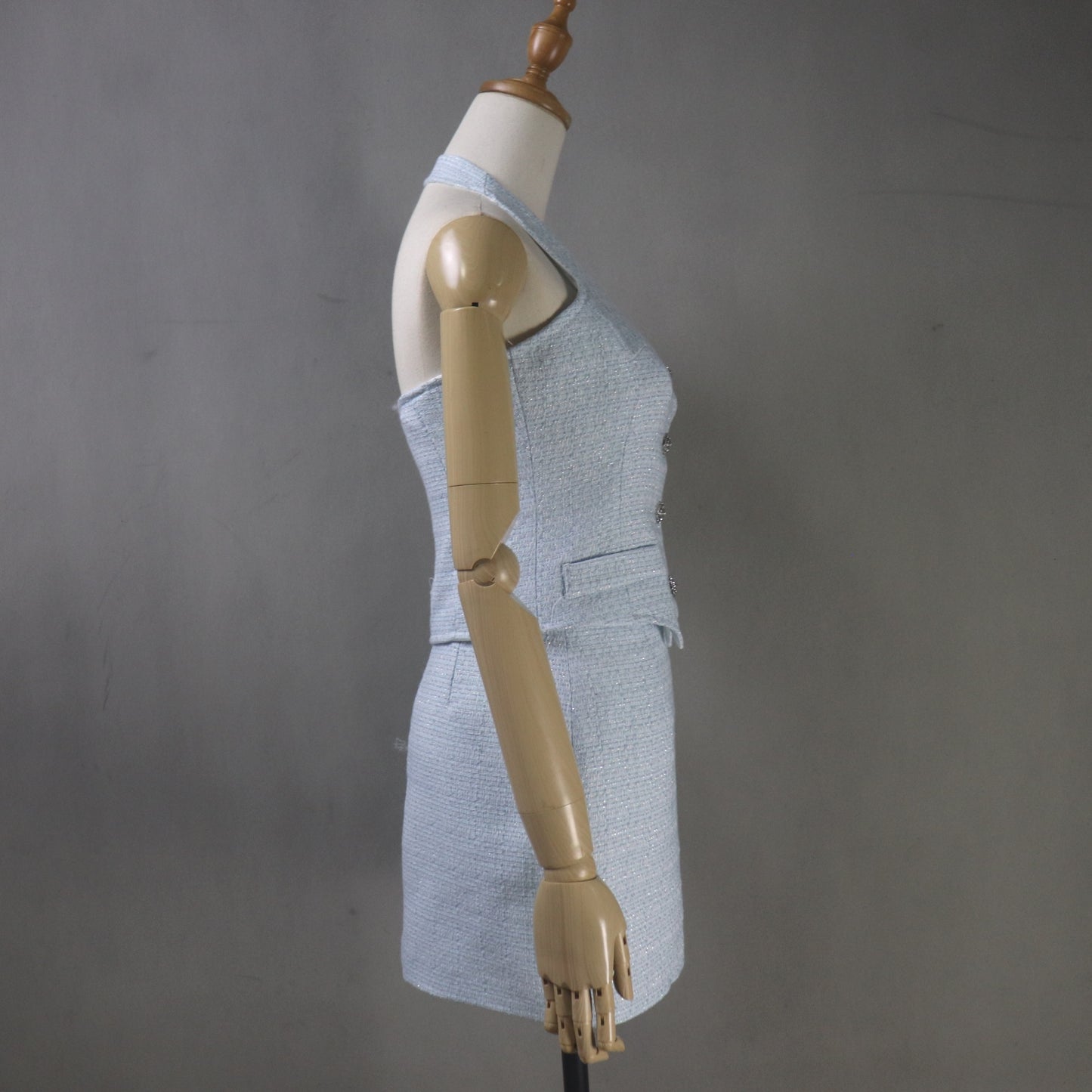 Mannequin wearing a gray sleeveless top and skirt against a gray background