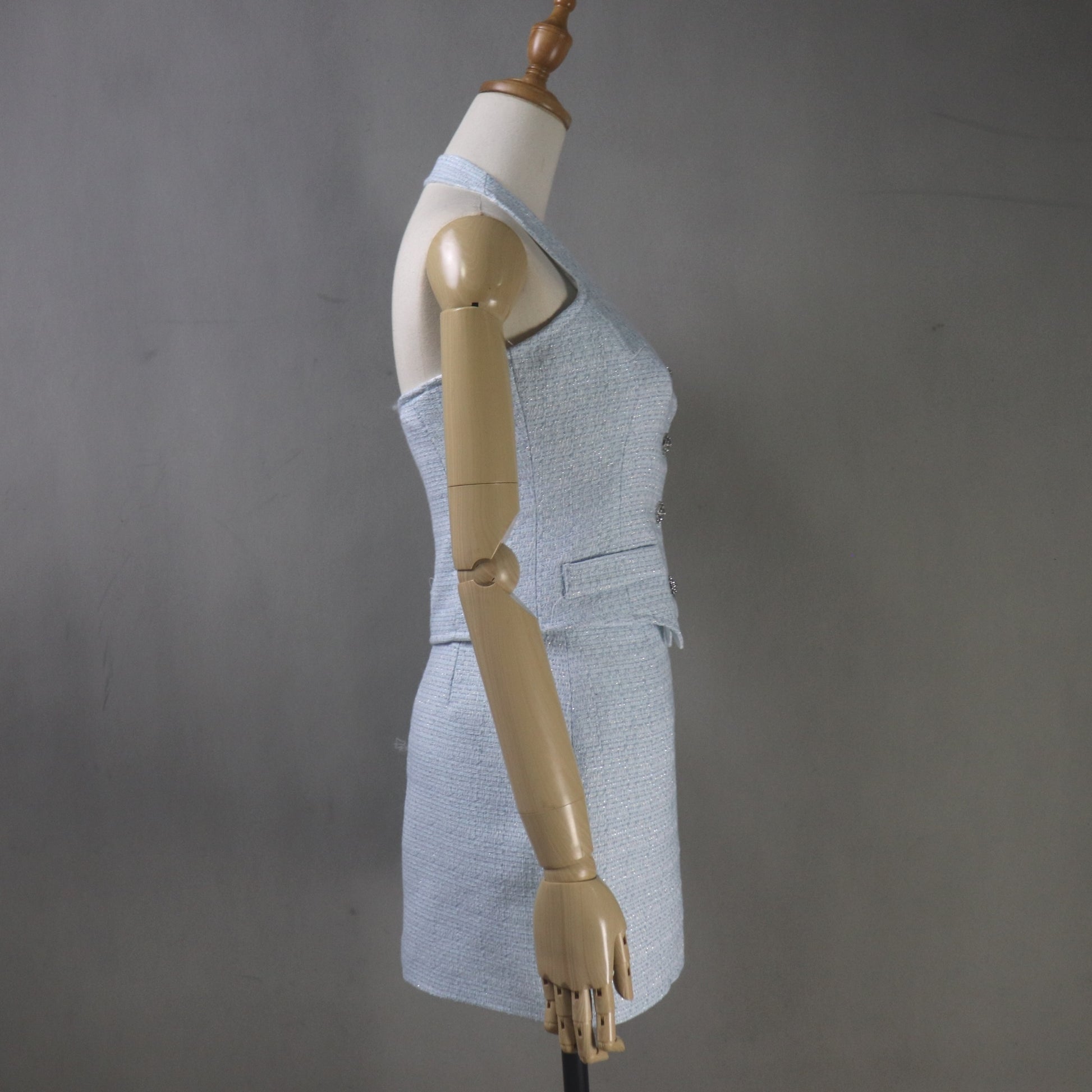 Mannequin wearing a gray sleeveless top and skirt against a gray background