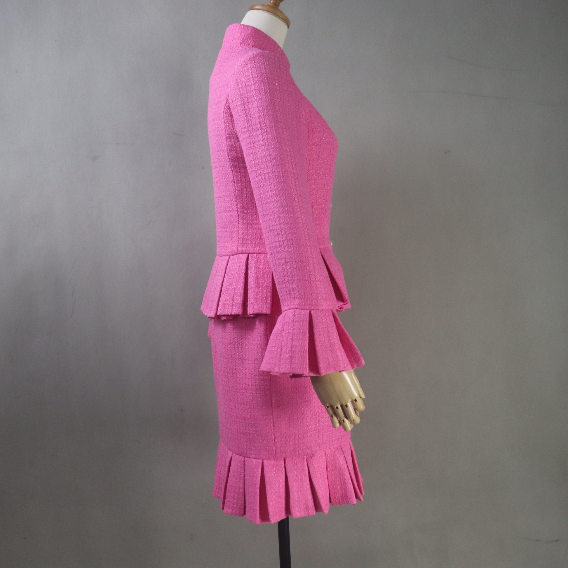 Custom tailored women's suit in textured pink tweed with vintage-inspired silhouette and premium craftsmanship.