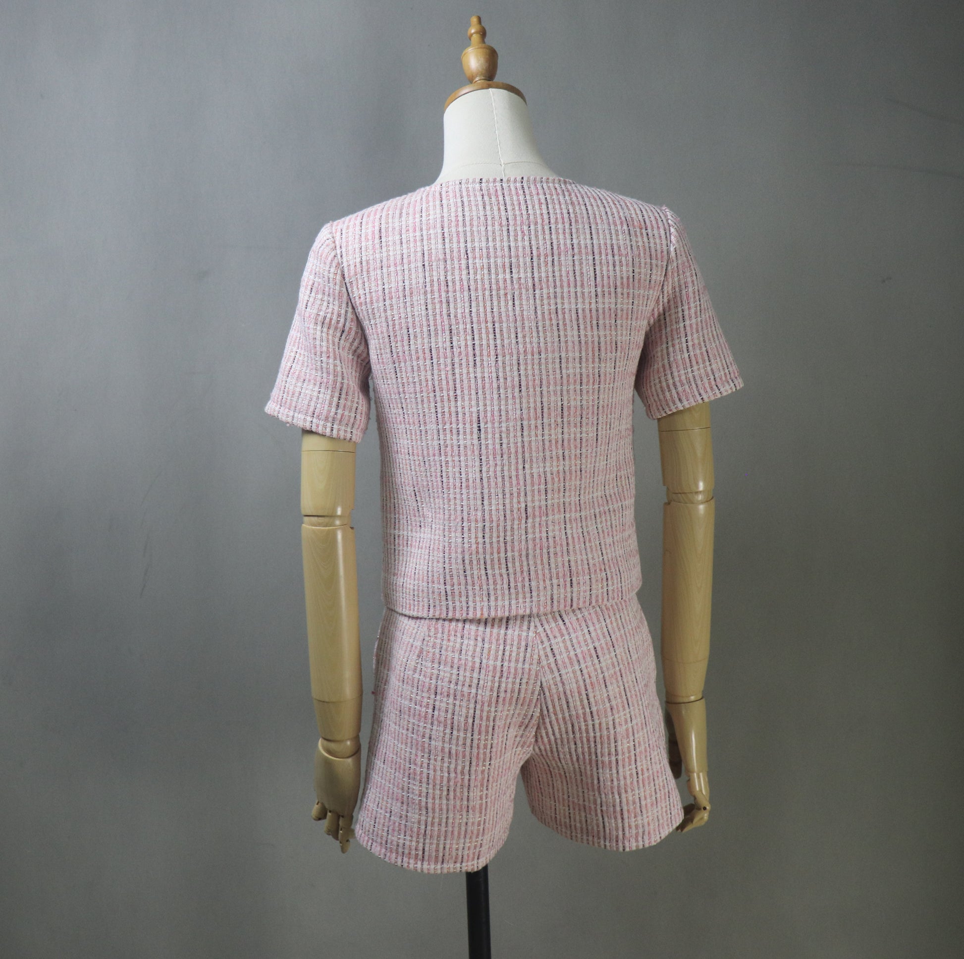 Back view of mannequin wearing pink tweed suit, highlighting the structured blazer seams and tailored fit of the shorts for a polished summer look.
