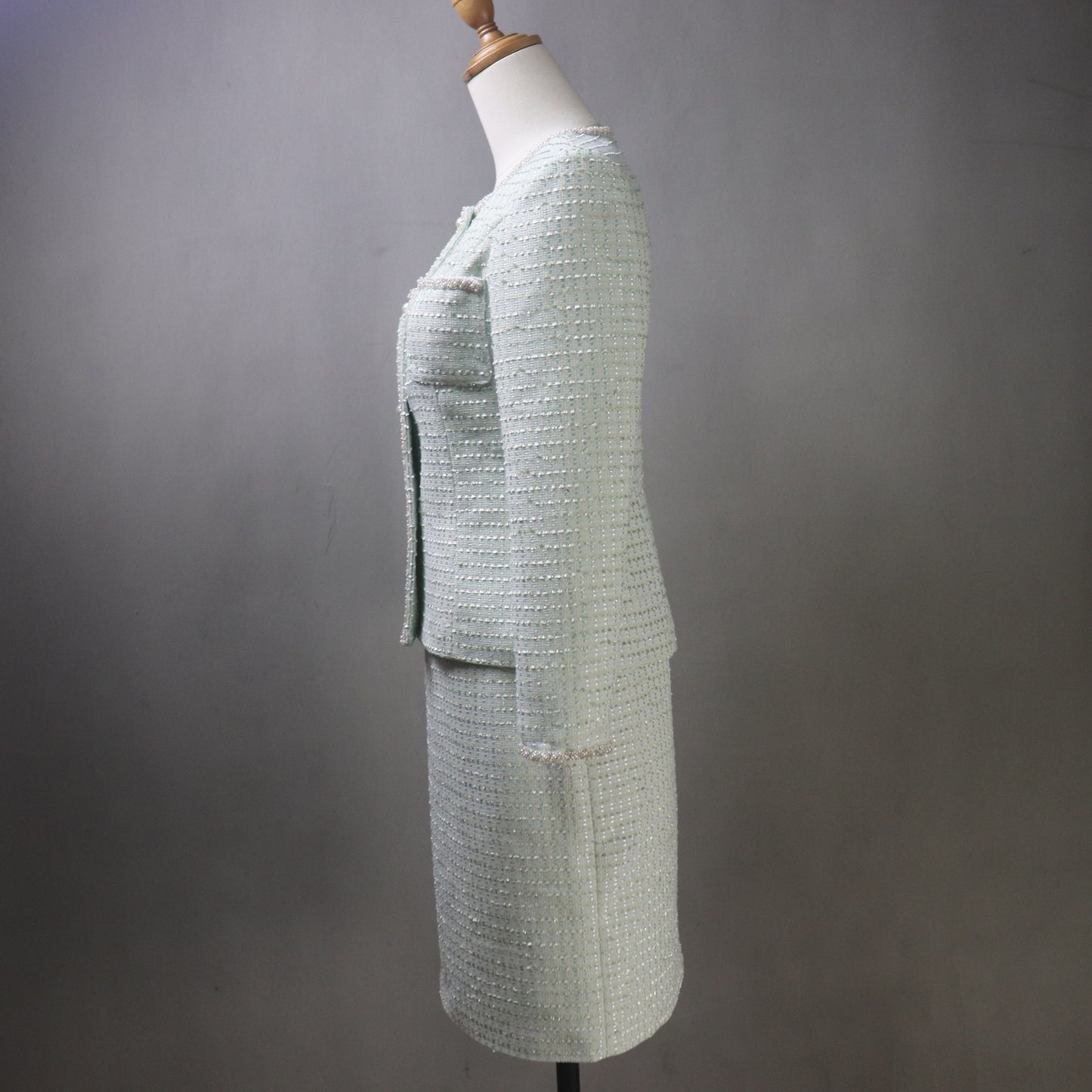 Light green textured suit on a mannequin against a plain background