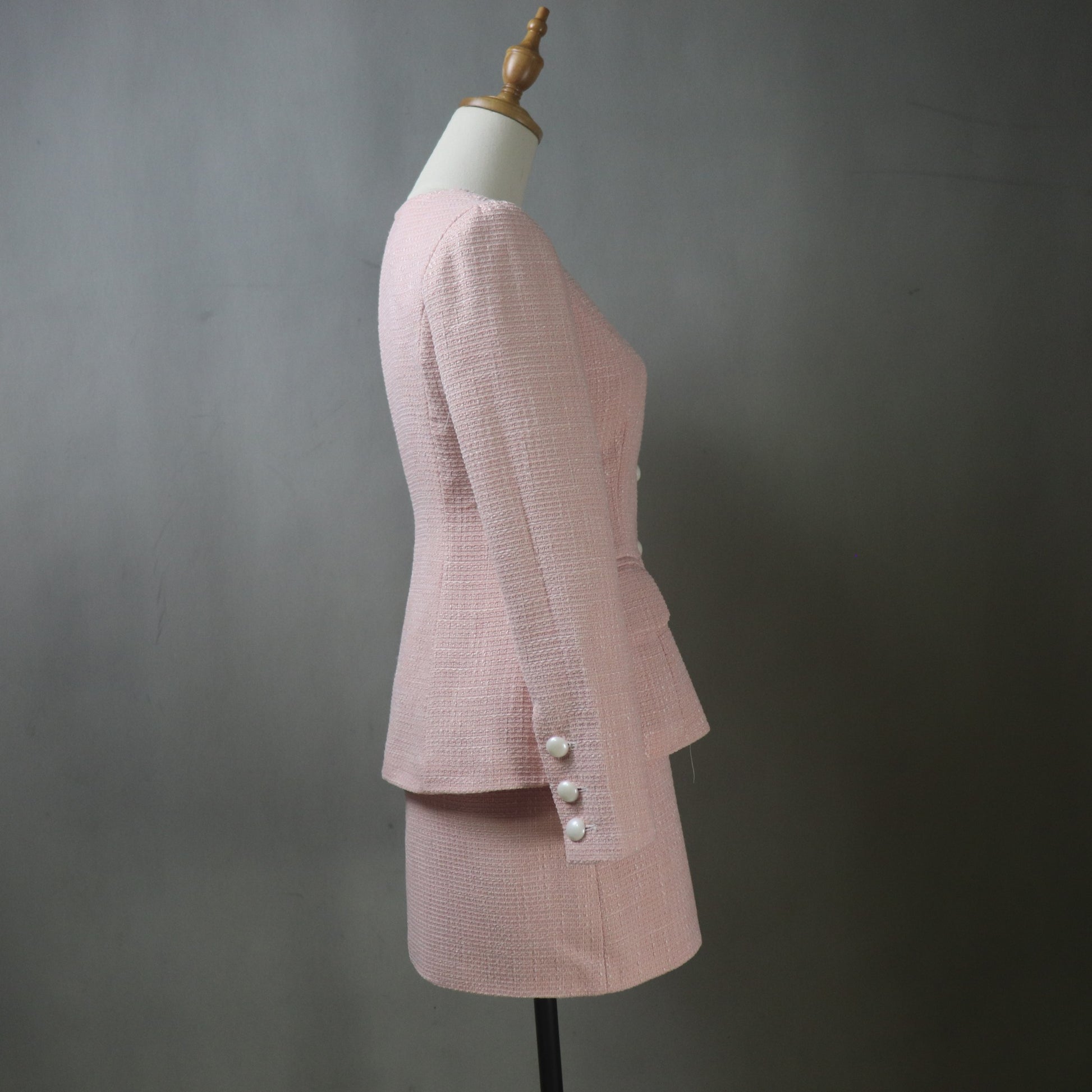 Pink checkered suit on a mannequin against a gray background
