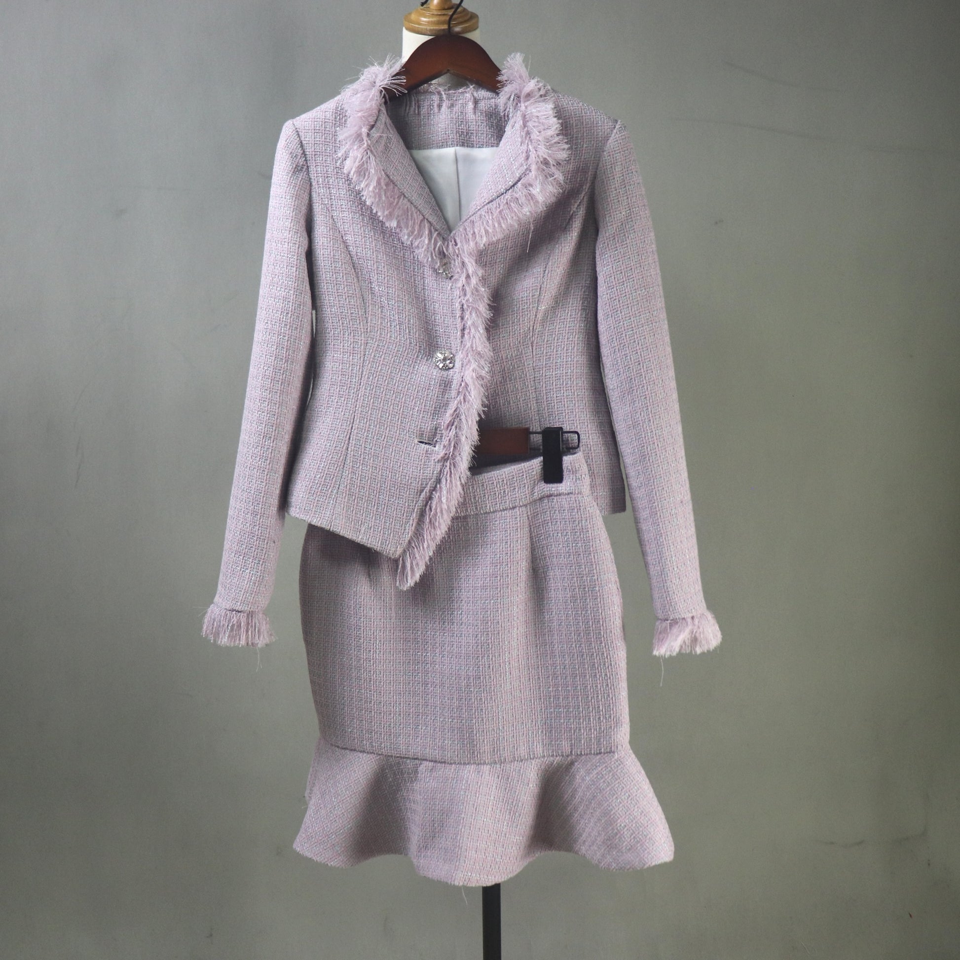 Purple suit with frayed edges on a mannequin against a gray background