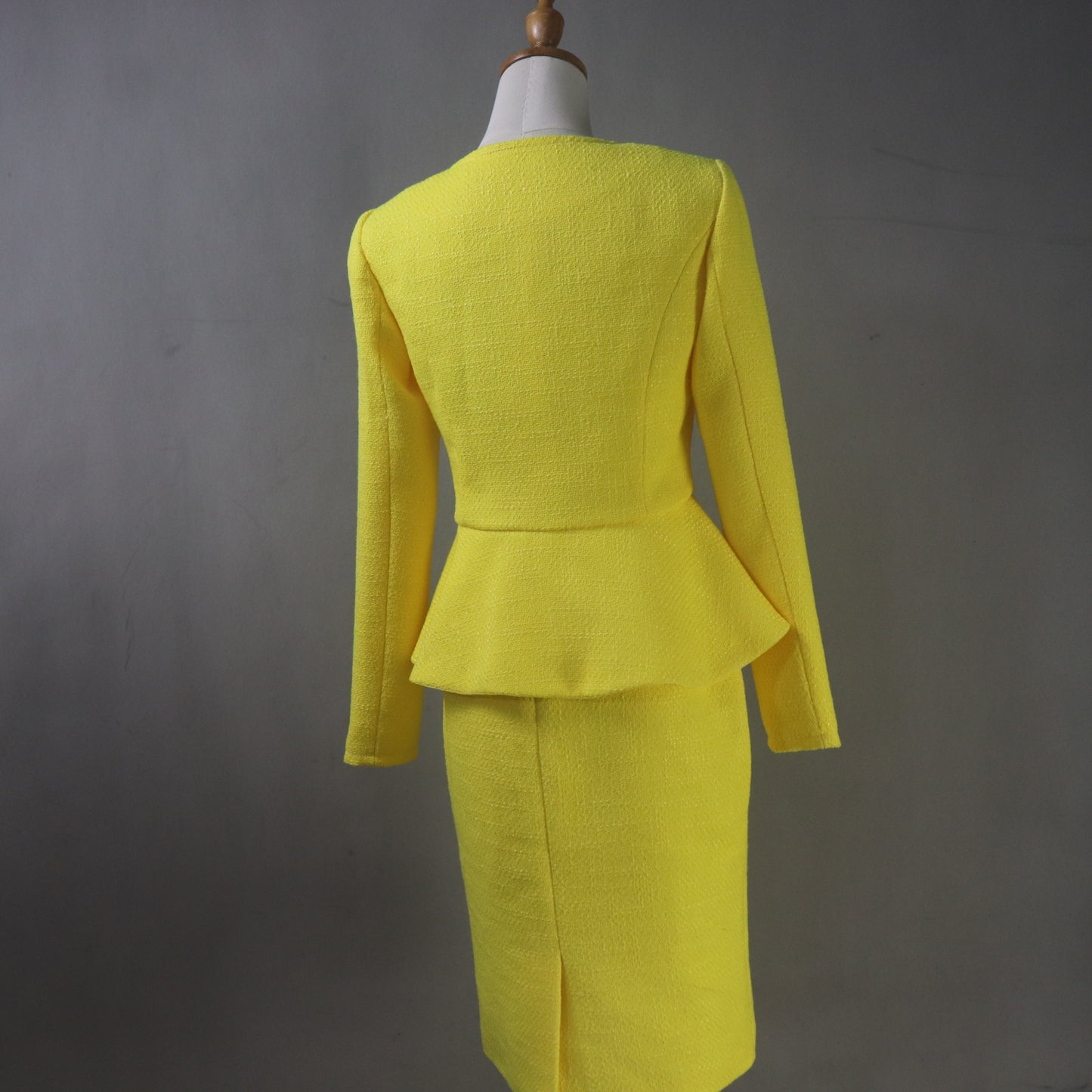 Custom-made yellow skirt suit featuring pearl button peplum jacket and fitted skirt, ideal for mother of the bride attire
