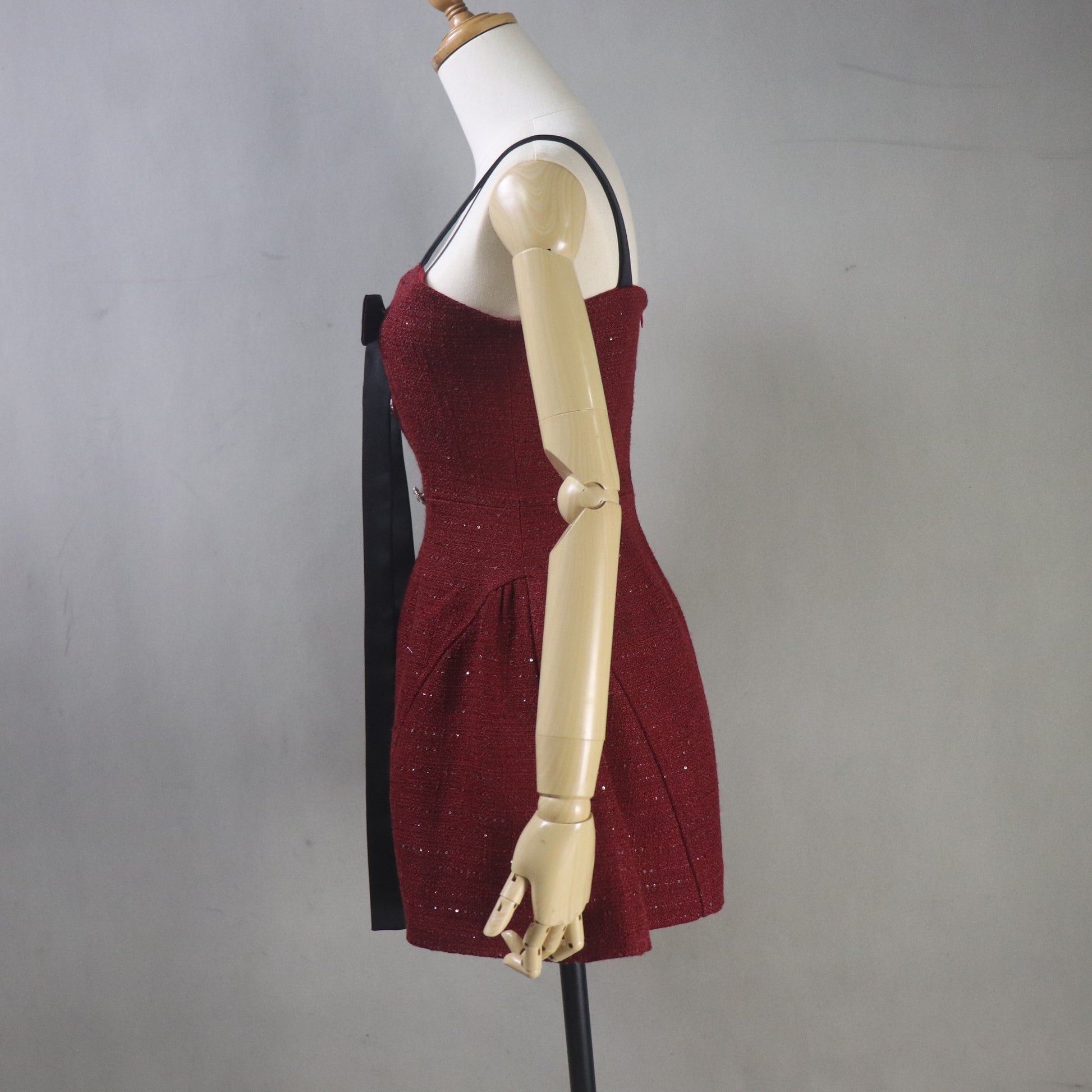 Maroon dress on a mannequin against a plain background
