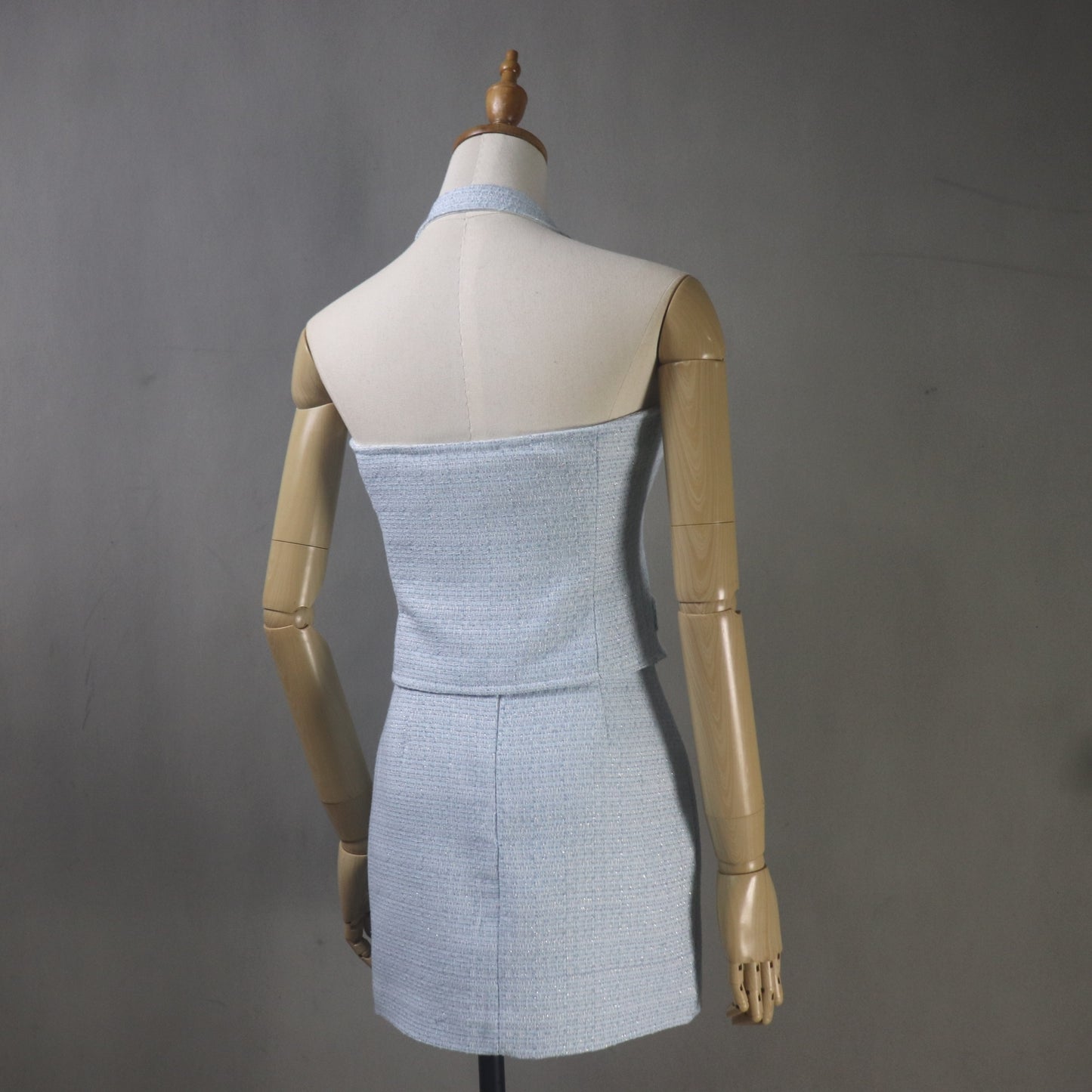 Mannequin wearing a light blue strapless dress against a gray background