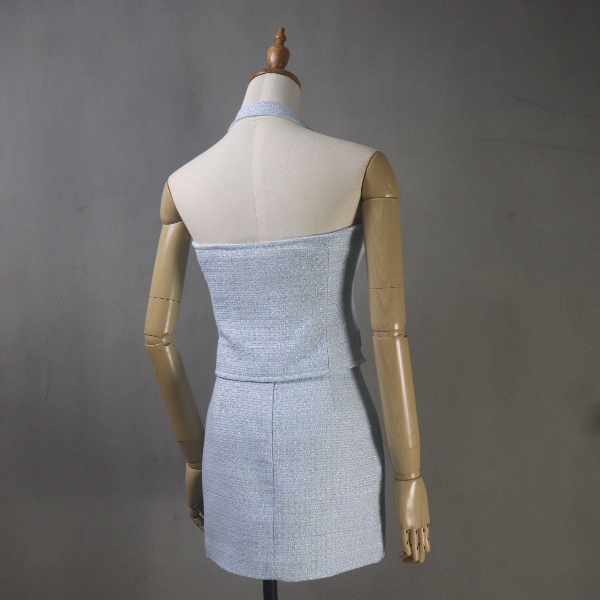 Mannequin wearing a light blue strapless dress against a gray background