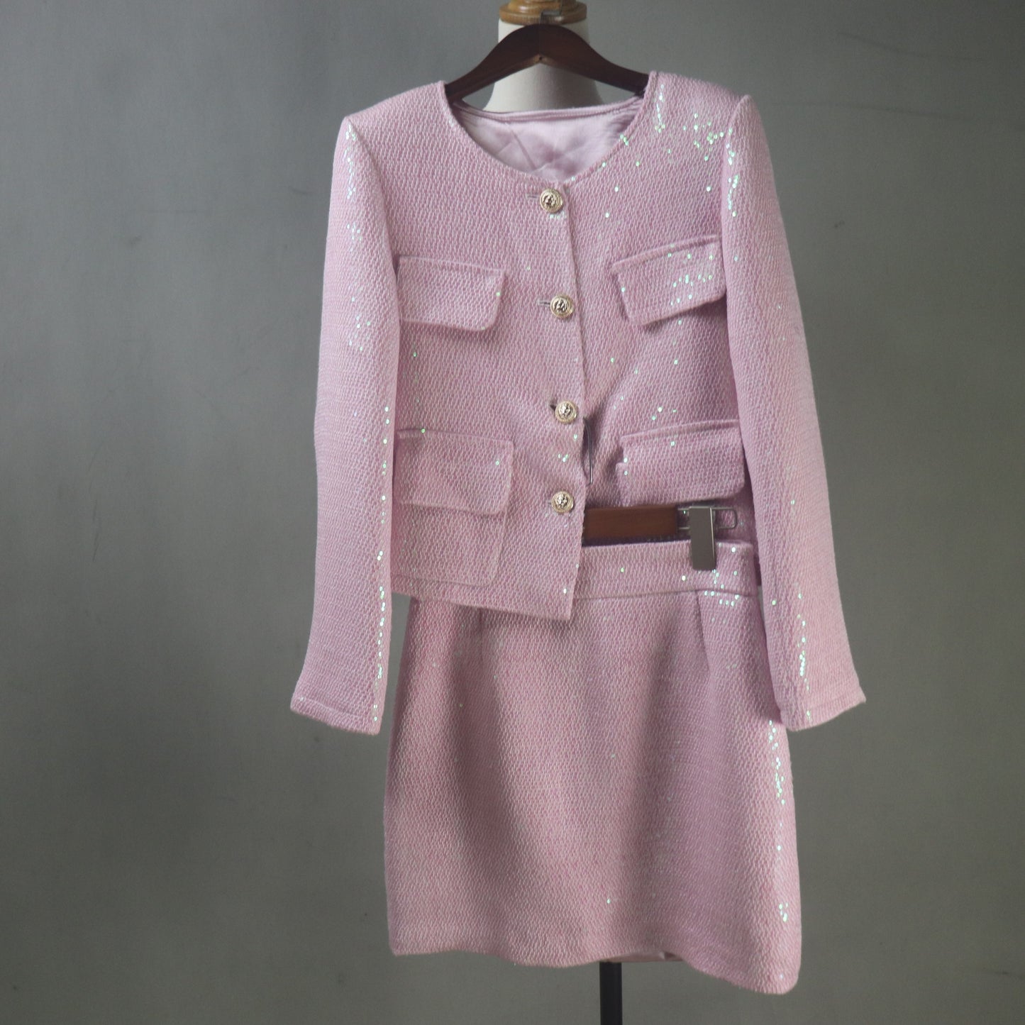 Pink sequin outfit on a mannequin against a gray background