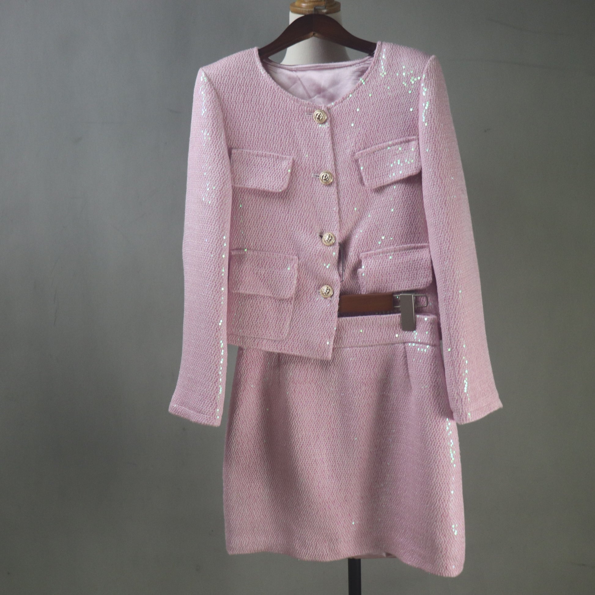 Pink sequin outfit on a mannequin against a gray background