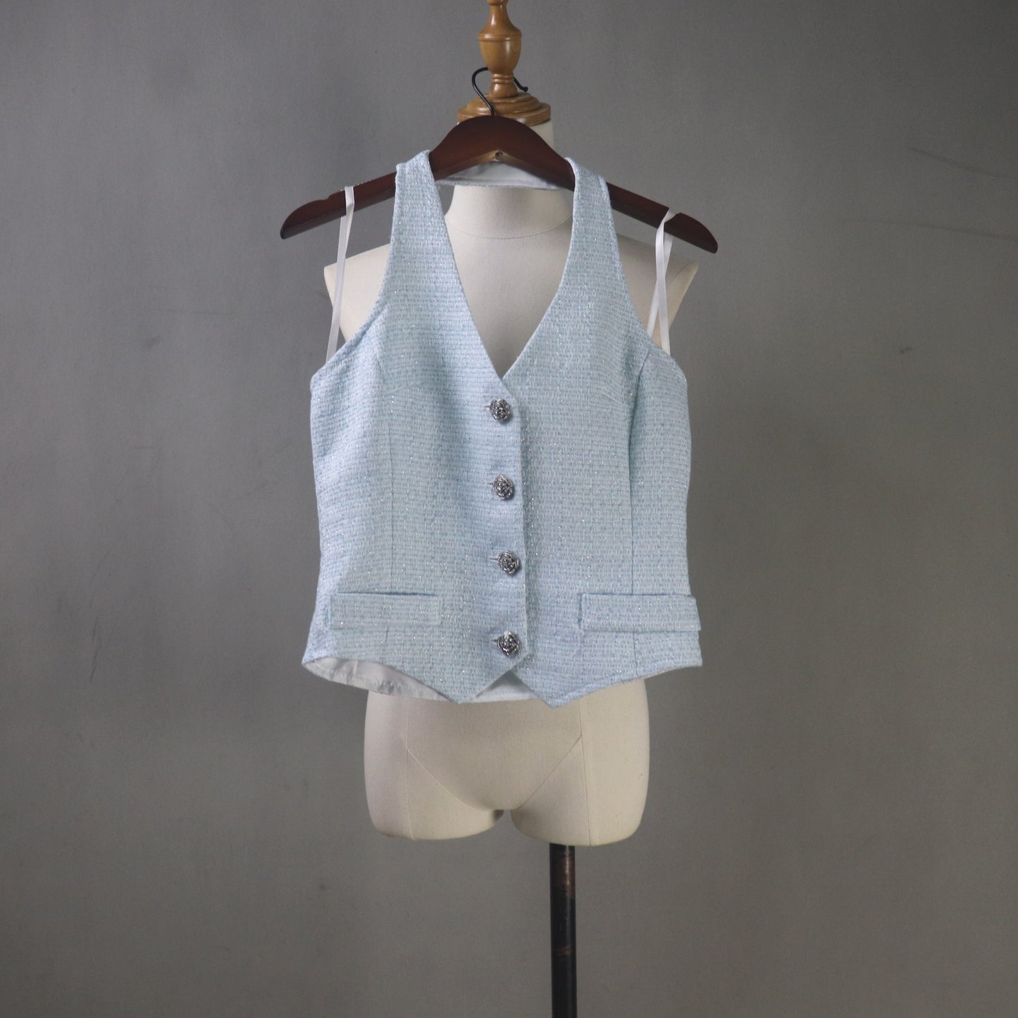 Light blue vest on a mannequin against a gray background