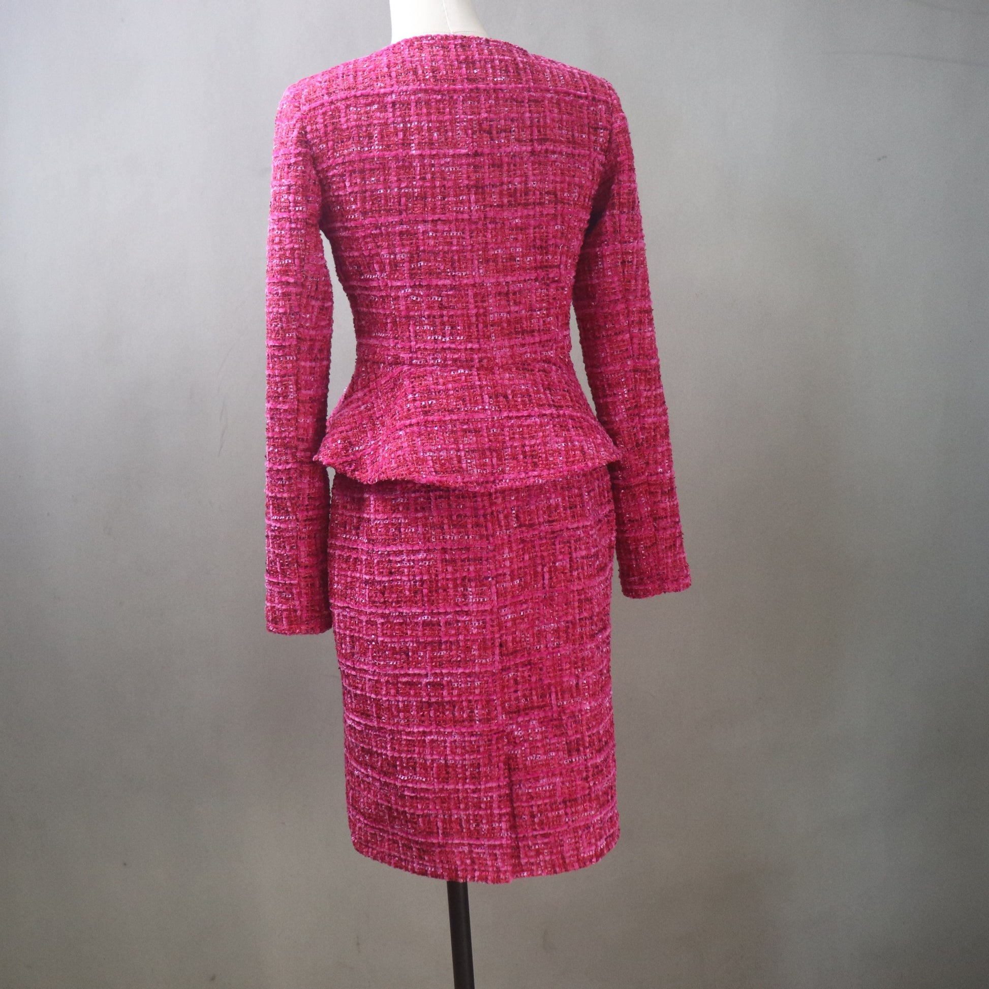 Pink textured skirt suit on a mannequin against a plain background