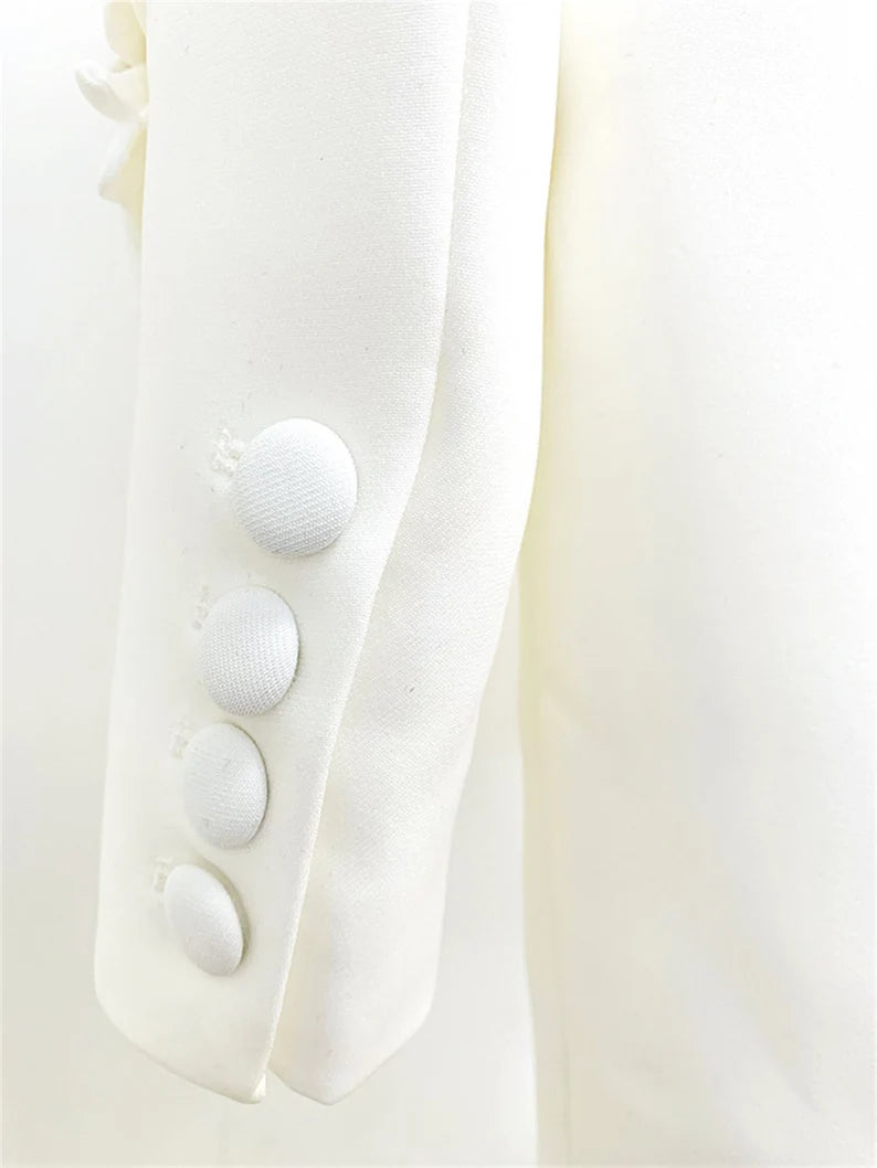 This appears to be a very fashionable and eye-catching pantsuit that would be ideal for a number of formal events. While the loose-fitting blazer and mid-high rise flare trousers provide comfort and freedom of movement, the white colour and 3D flower decorations are sure to make a bold statement.