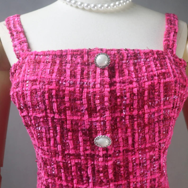 A hand-sewn tweed dress in hot pink color can be a stylish and unique addition to any woman's wardrobe. Tweed is a classic fabric that is known for its durability and texture, while hot pink adds a pop of color and modern flair to the dress.  The length of the dress can vary depending on your preference and occasion. A mini-length dress can be a great option for a fun and casual look, while a knee-length dress can be more appropriate for formal or professional settings.