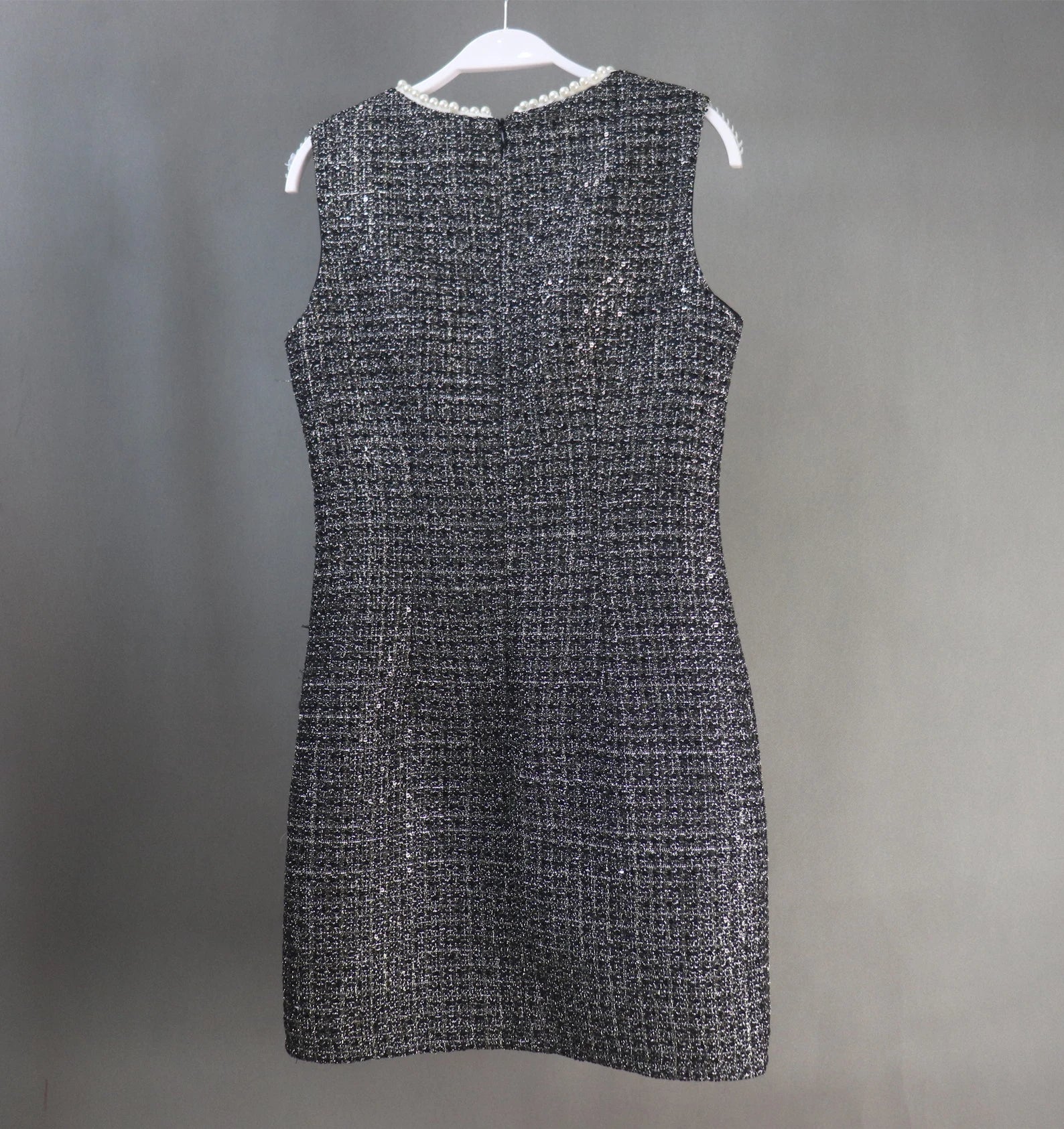 This dazzling FASHION Sequinned tweed little dress will stun everyone with its glamorous notes! This slim-fit black dress is made of a mid-weight tweed with dazzling lame accents, small sequins with white chiffon trims, and is lined with black satin. This dress also has a high neckline with trims, a sleeveless design,